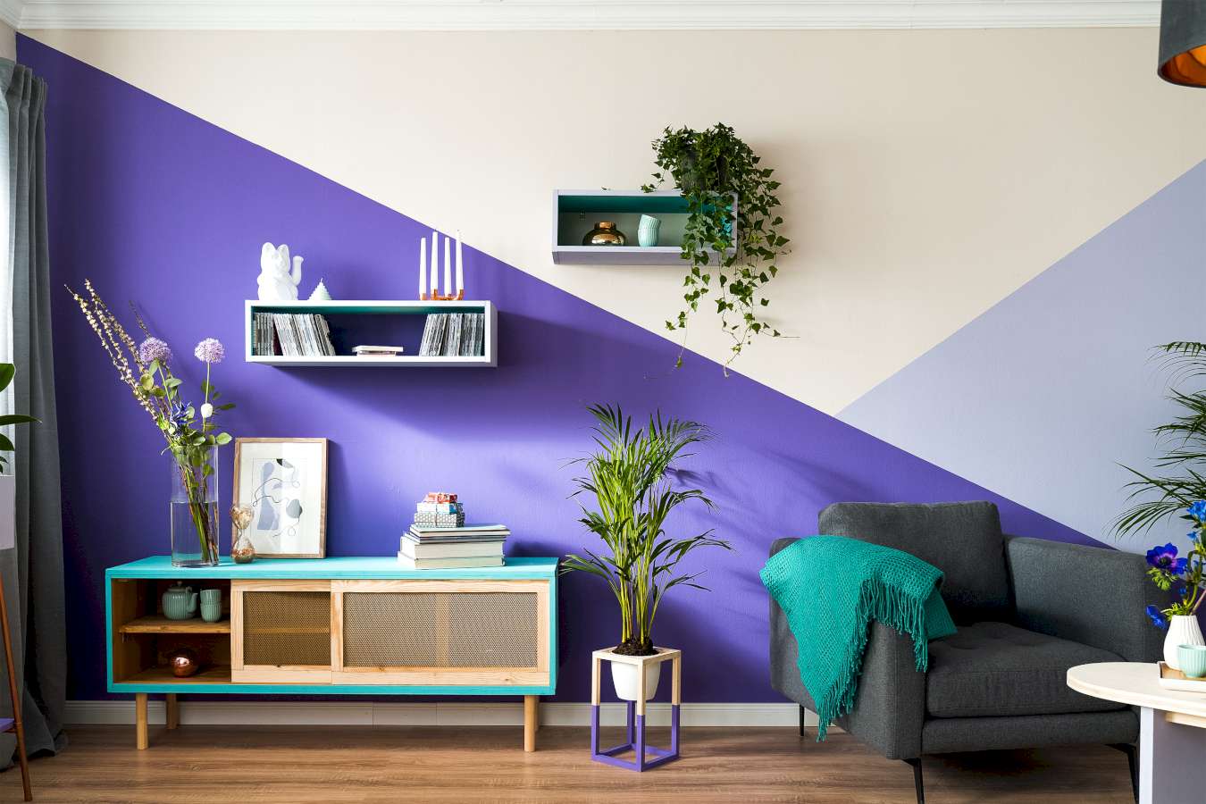 Eine Wand, die große geometrische Formen in der Trendfarbe Blau-Lila als Wandgestaltung nutzt.