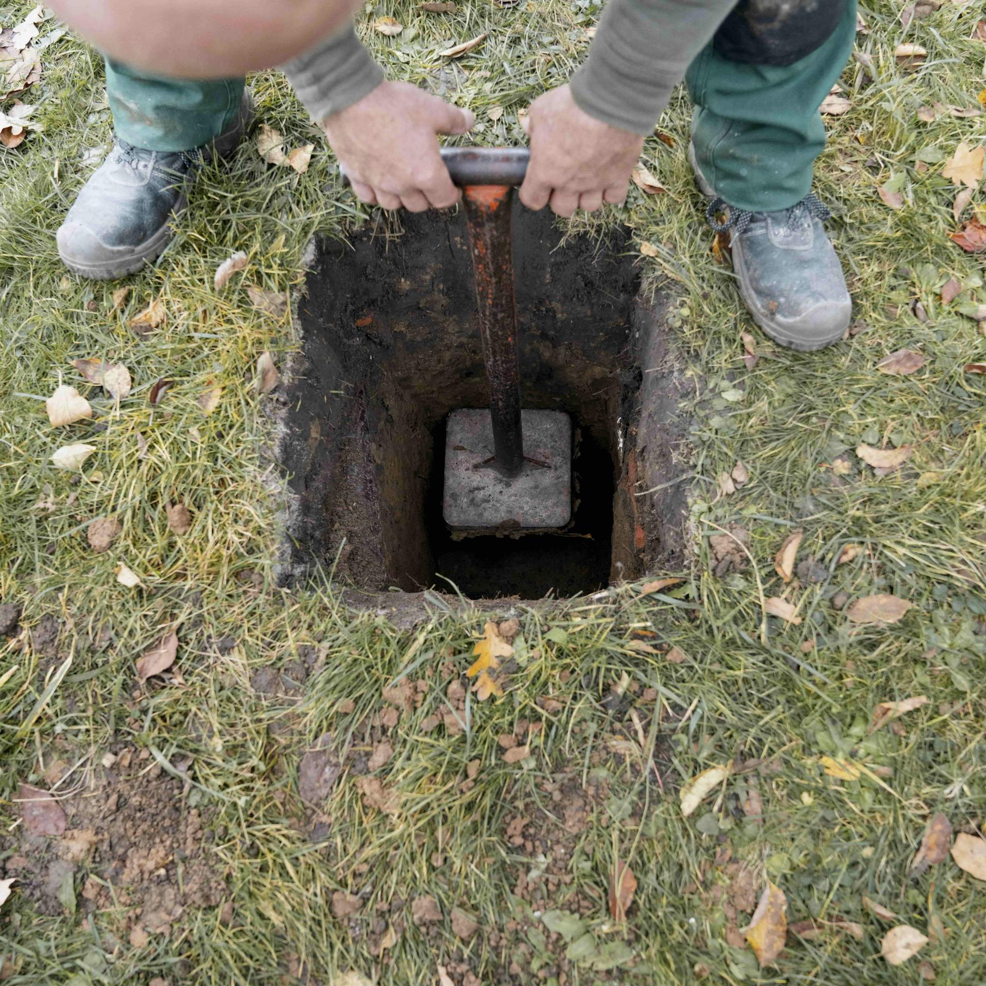 Heimwerker verfestigen den Boden in einem ausgeschachteten Loch