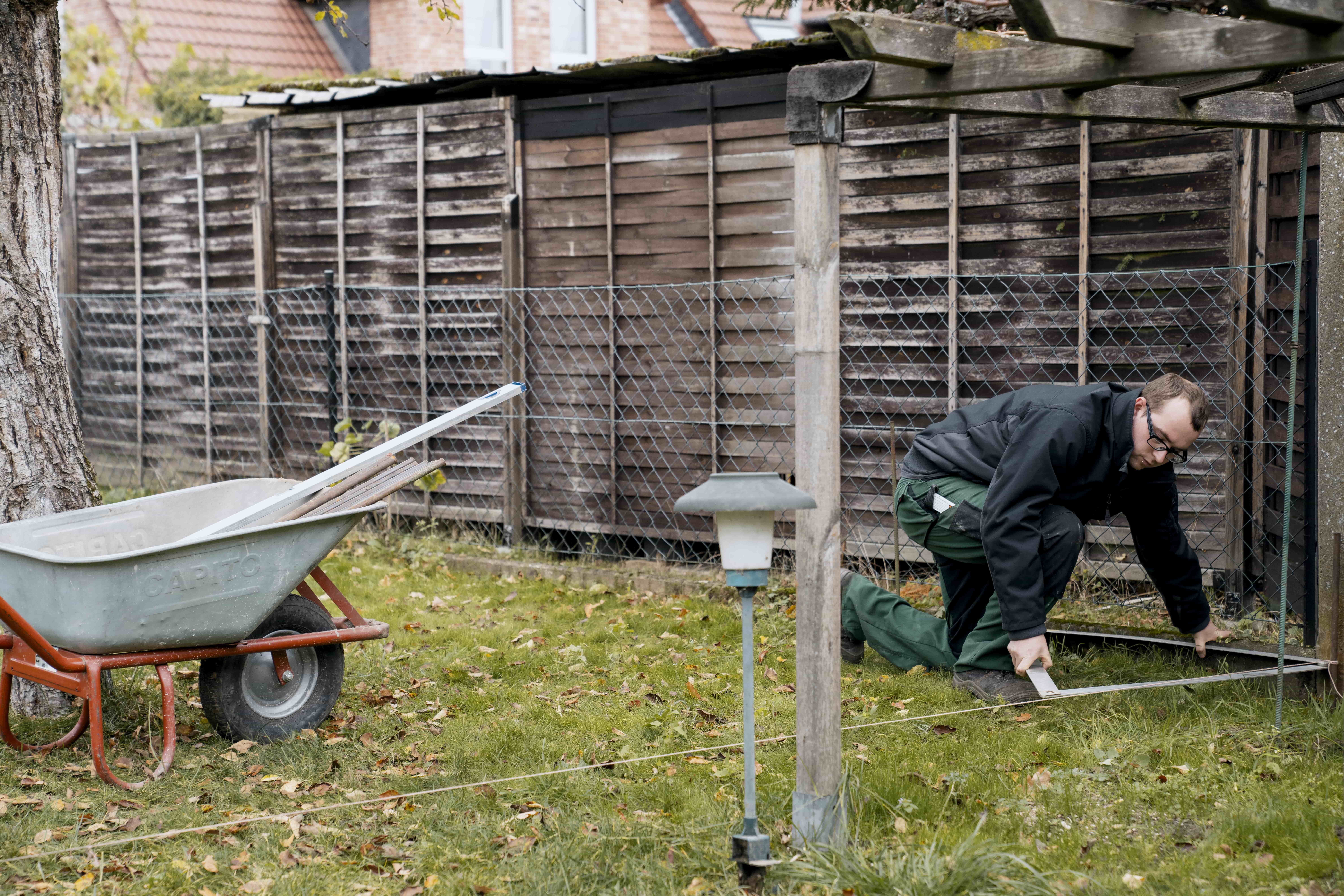 Heimwerker misst die Ausrichtung eines Schnurrgerüstes nach.