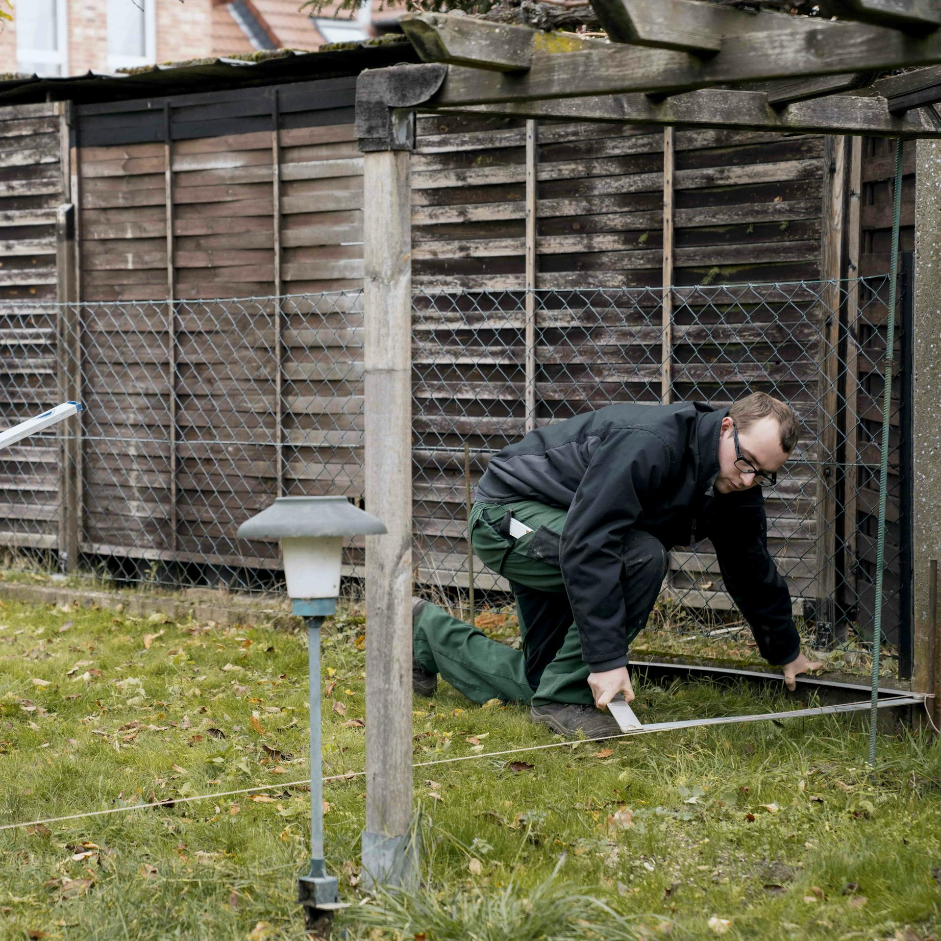Heimwerker misst die Ausrichtung eines Schnurrgerüstes nach.