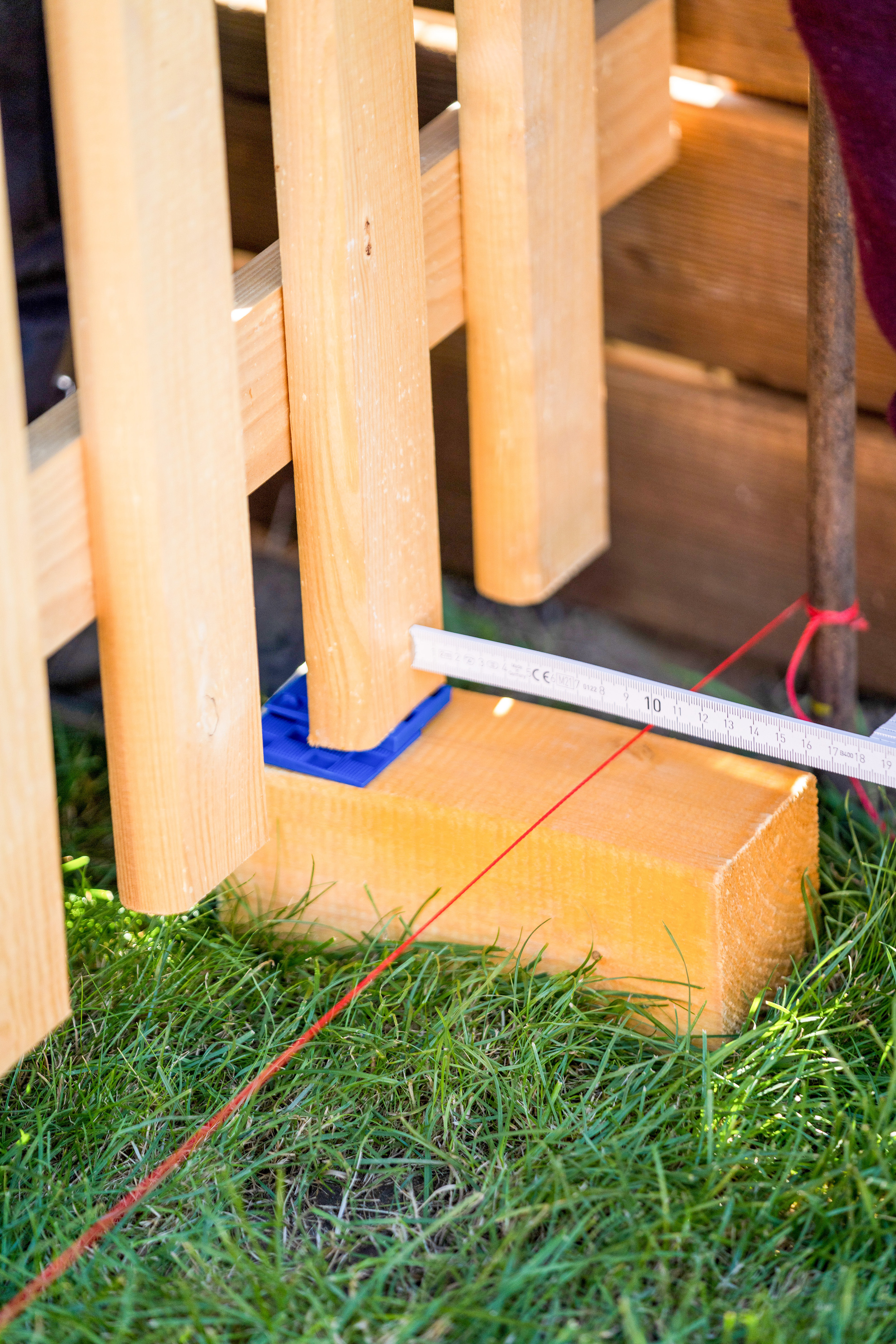 Lattenzaun steht auf einem Holzklotz