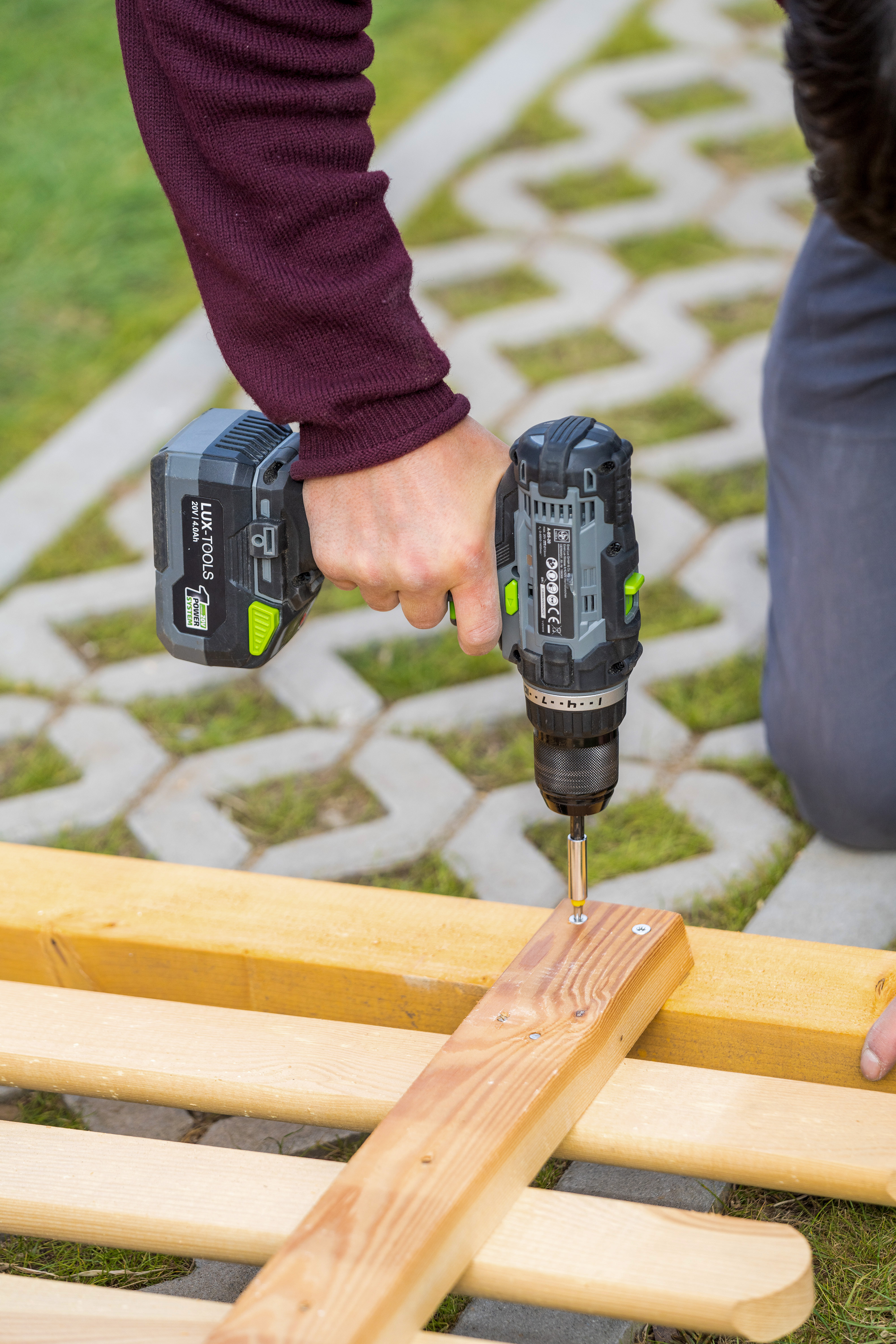 Holzlatte wird an Zaunelement geschraubt