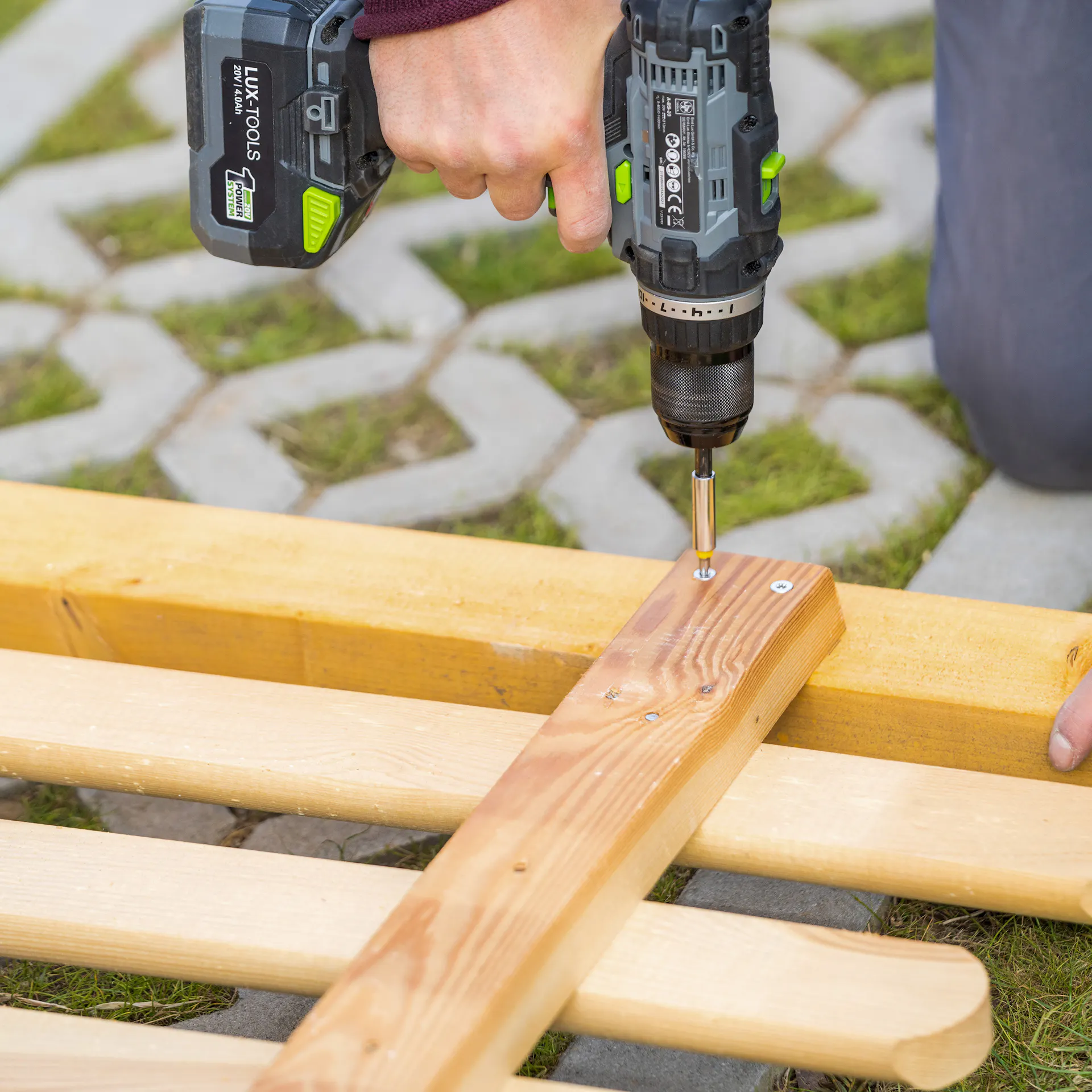 Holzlatte wird an Zaunelement geschraubt