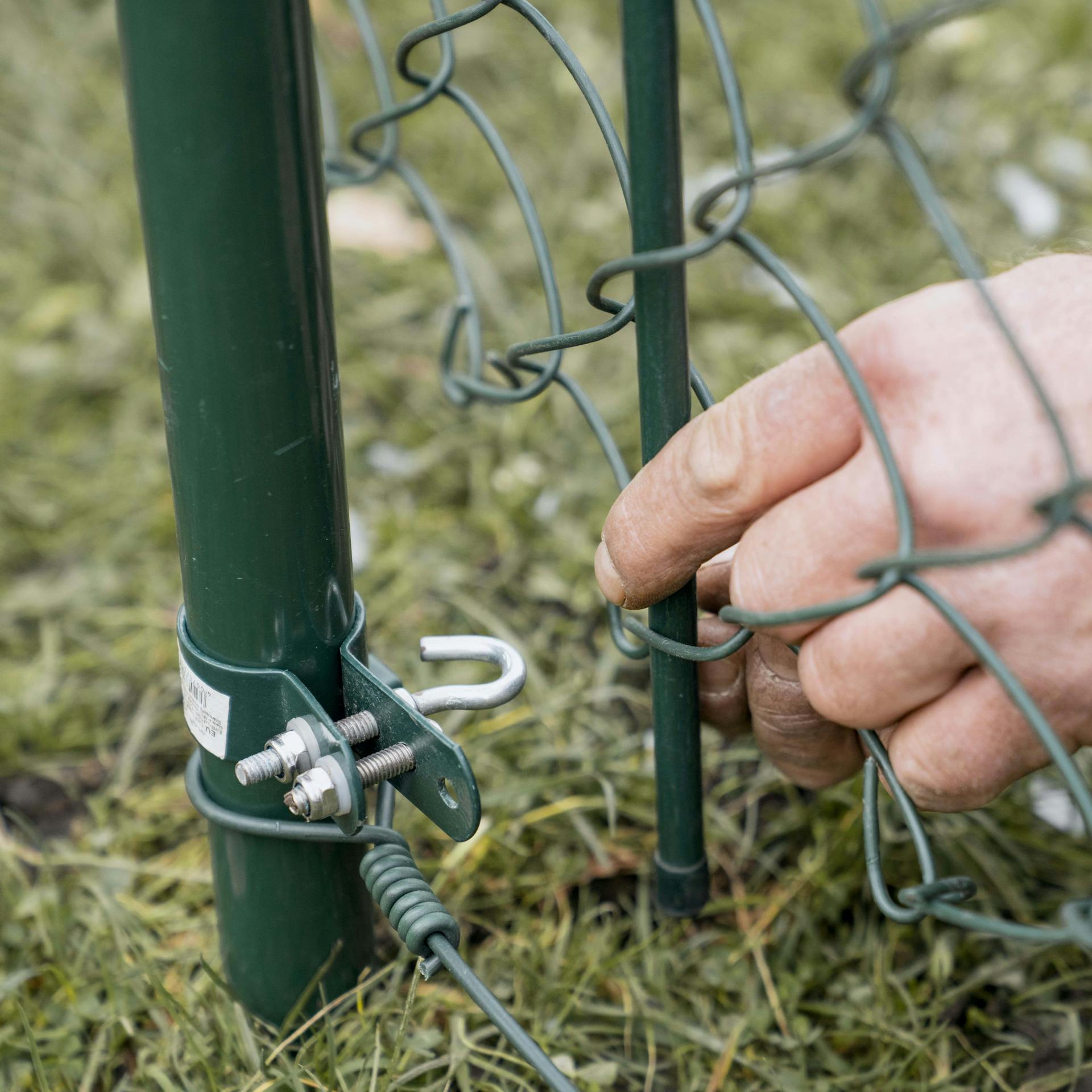 Pracovník zacvakne napínaciu tyč do háku.