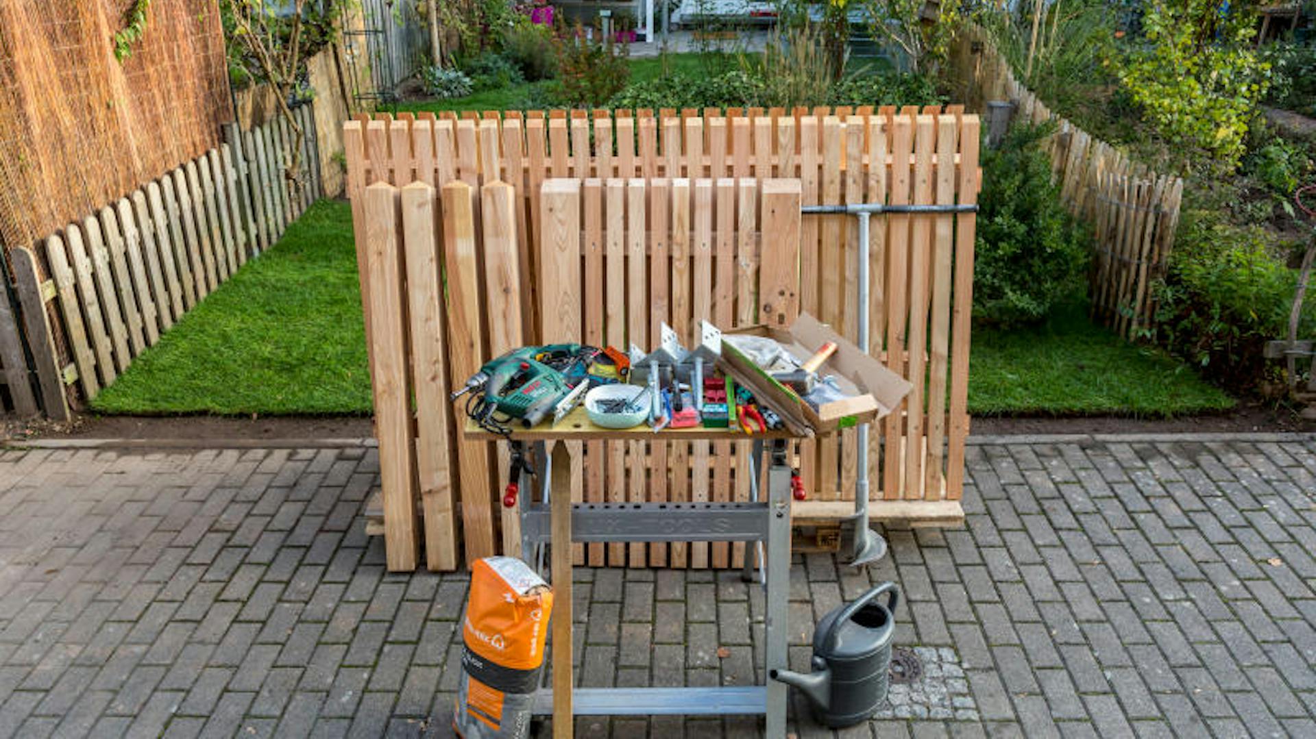 Werkzeug und Zaunelemente stehen bereit.