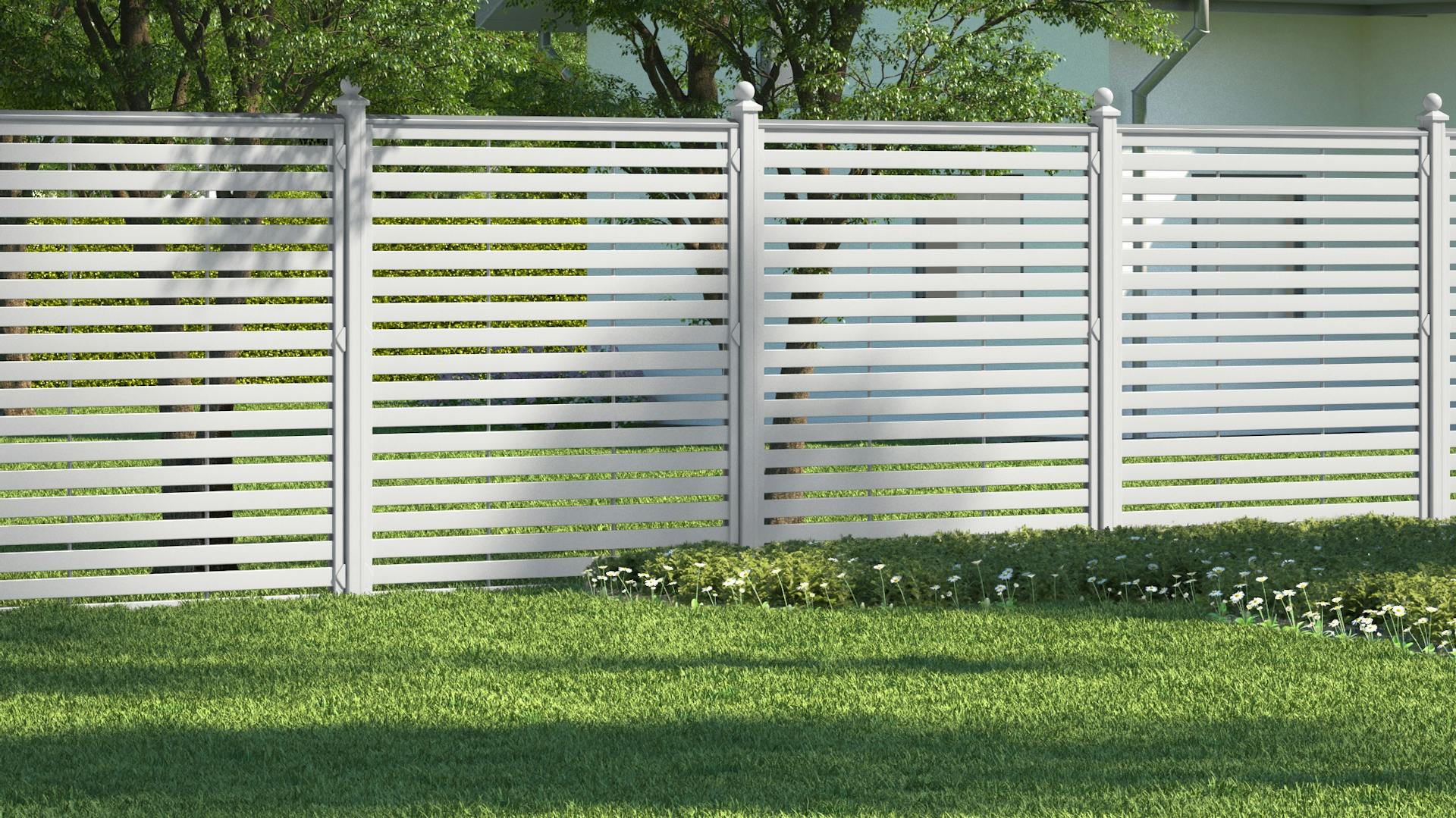 Ein Zaun aus weißem Kunststoff dient als Sichtschutz.