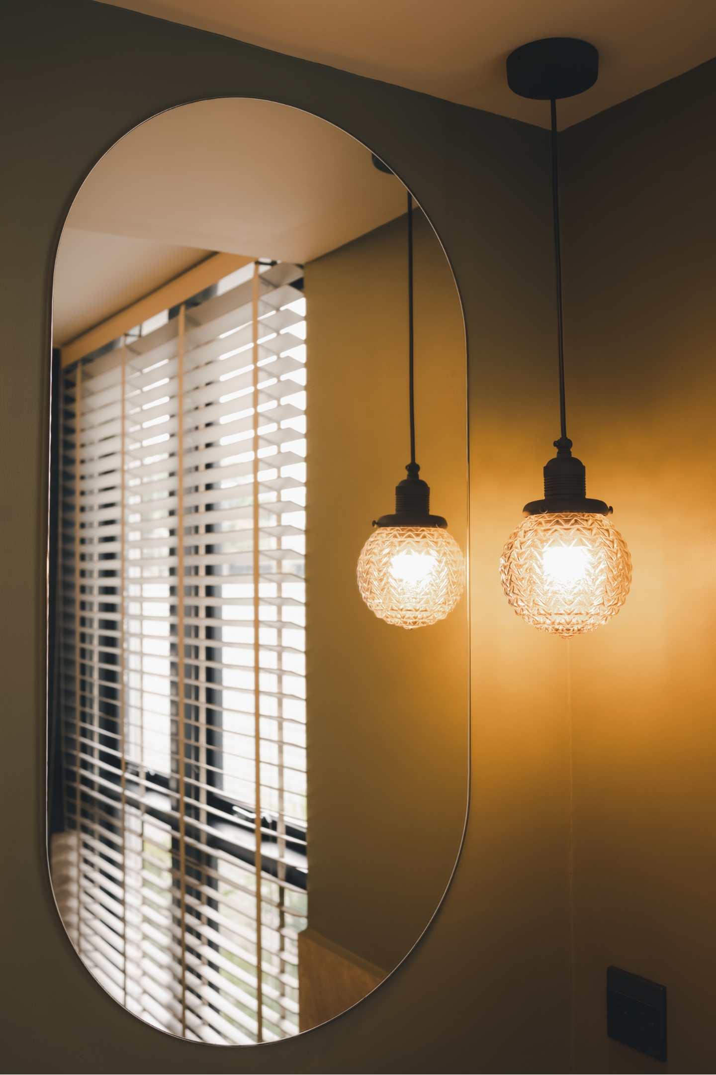 Specchio in bagno con lampade a sfera e luce gialla calda