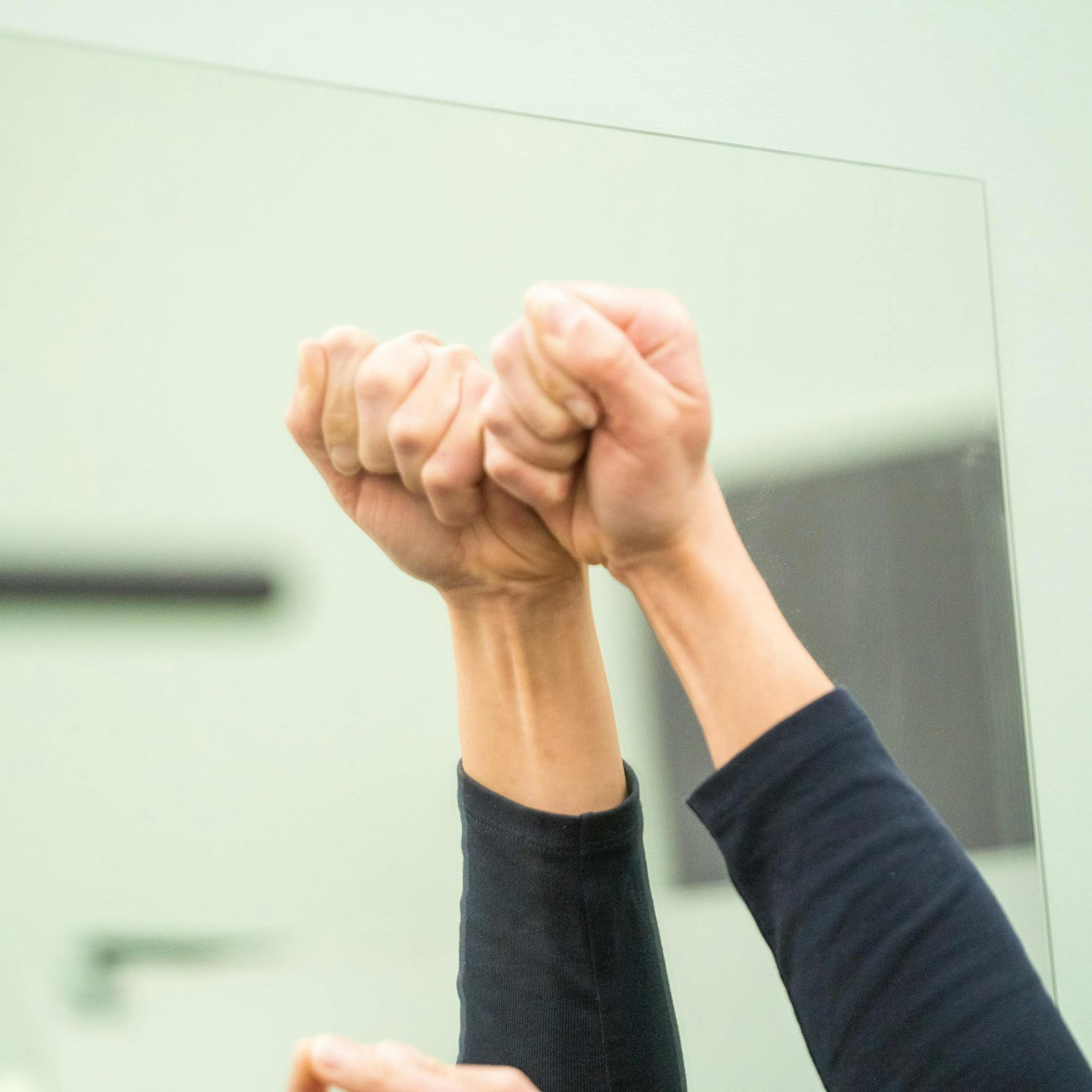 Jemand drückt einen Wandspiegel an der Wand fest.