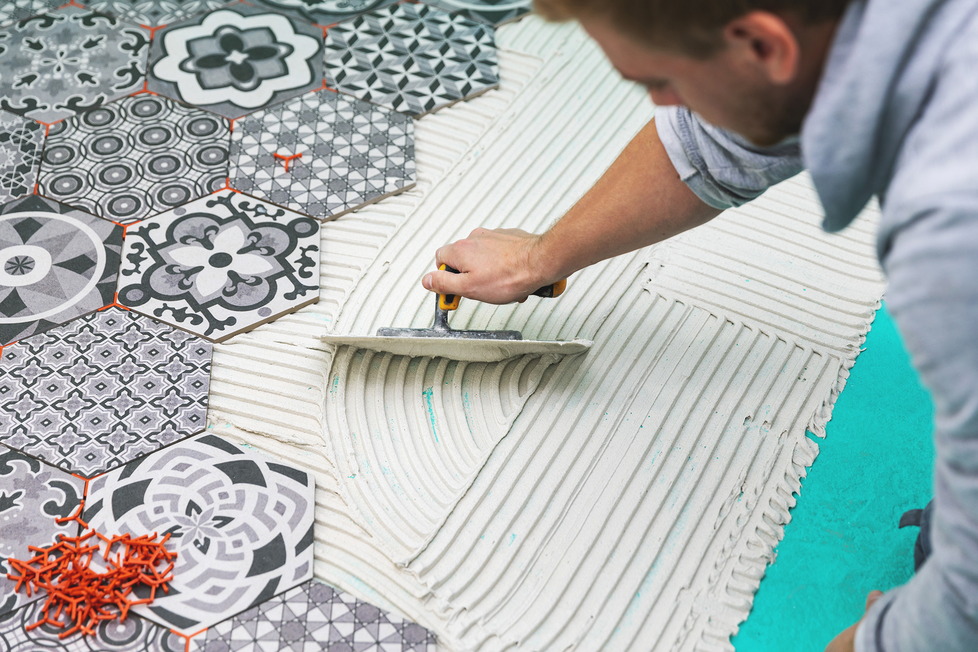Person fliest Boden mit Mosaikfliesen.