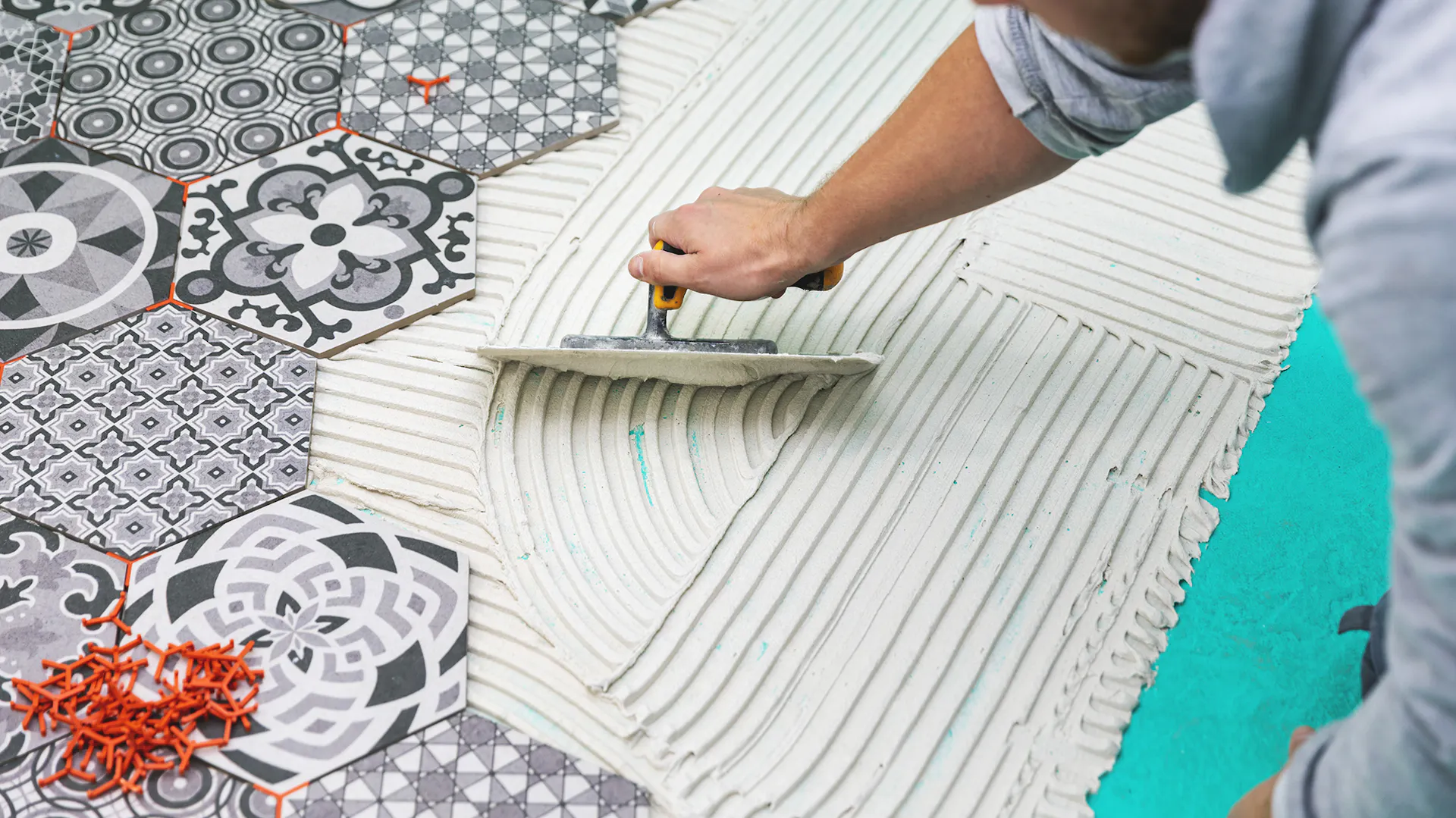Person fliest Boden mit Mosaikfliesen.