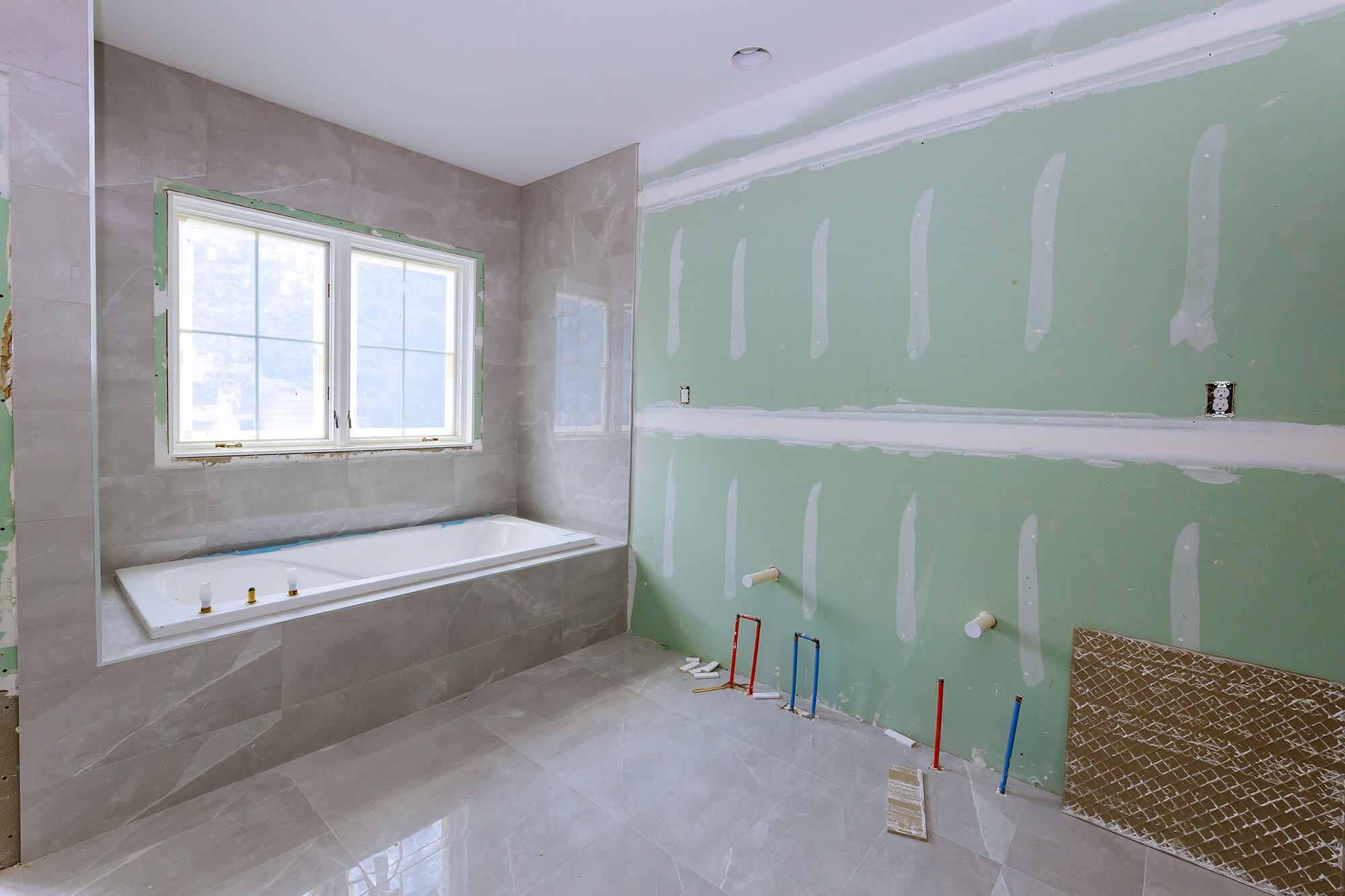 Badezimmer mit Badewanne im Rohbau. 