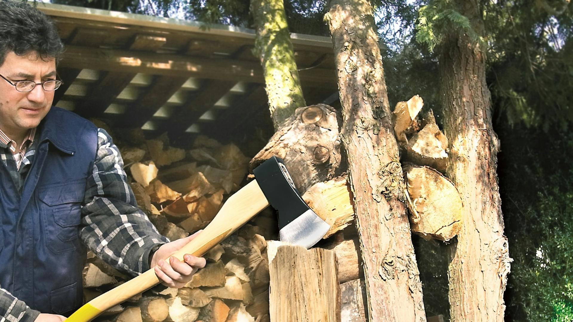 Mann hackt Holz mit einer Axt