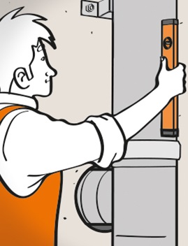 Der Heimwerker prüft mit der Wasserwaage, ob der Schornstein gerade ausgerichtet ist.