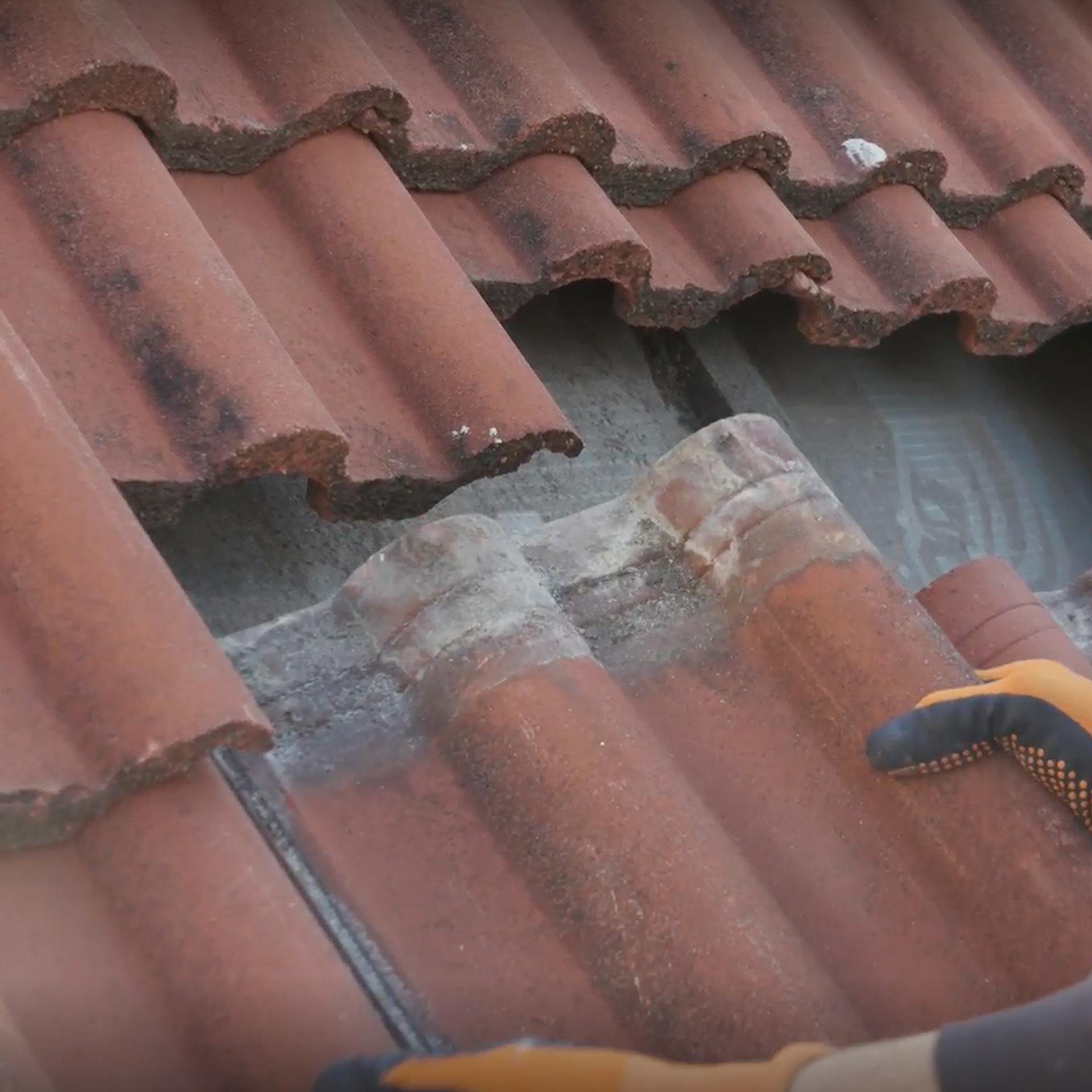 Pracovník ukladá nové strešné škridly.