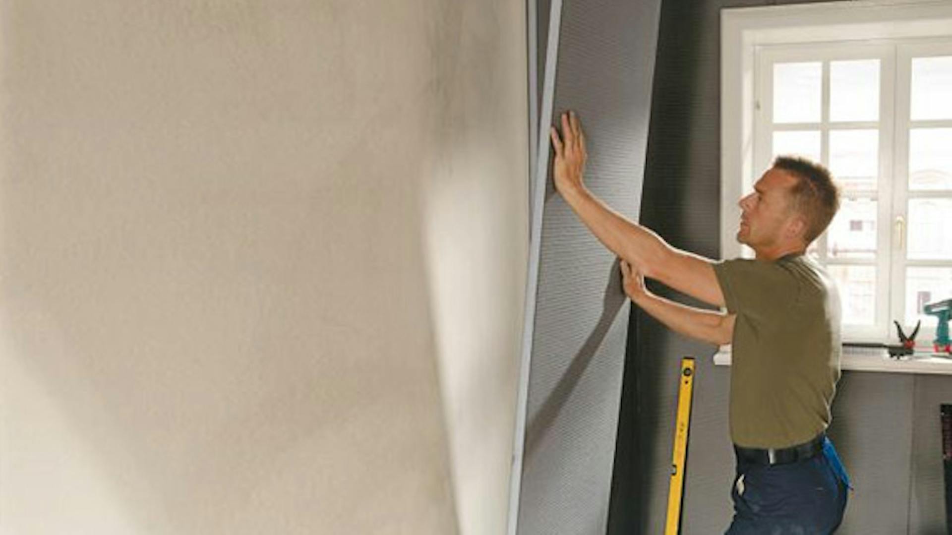 Heimwerker dämmt Außenwand vom Haus von innen.