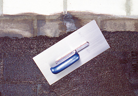 La parete in cantina è ricoperta dall’esterno con uno spesso strato bituminoso per l’isolamento.