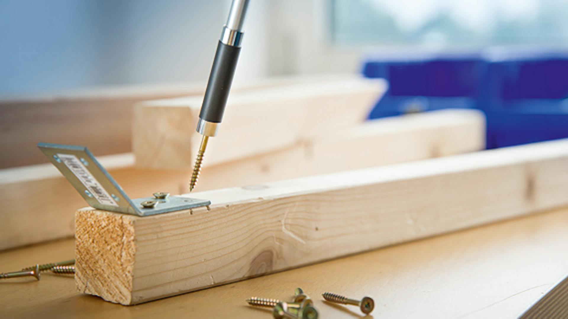 Akkuschrauber mit Schraube auf Holzbalken