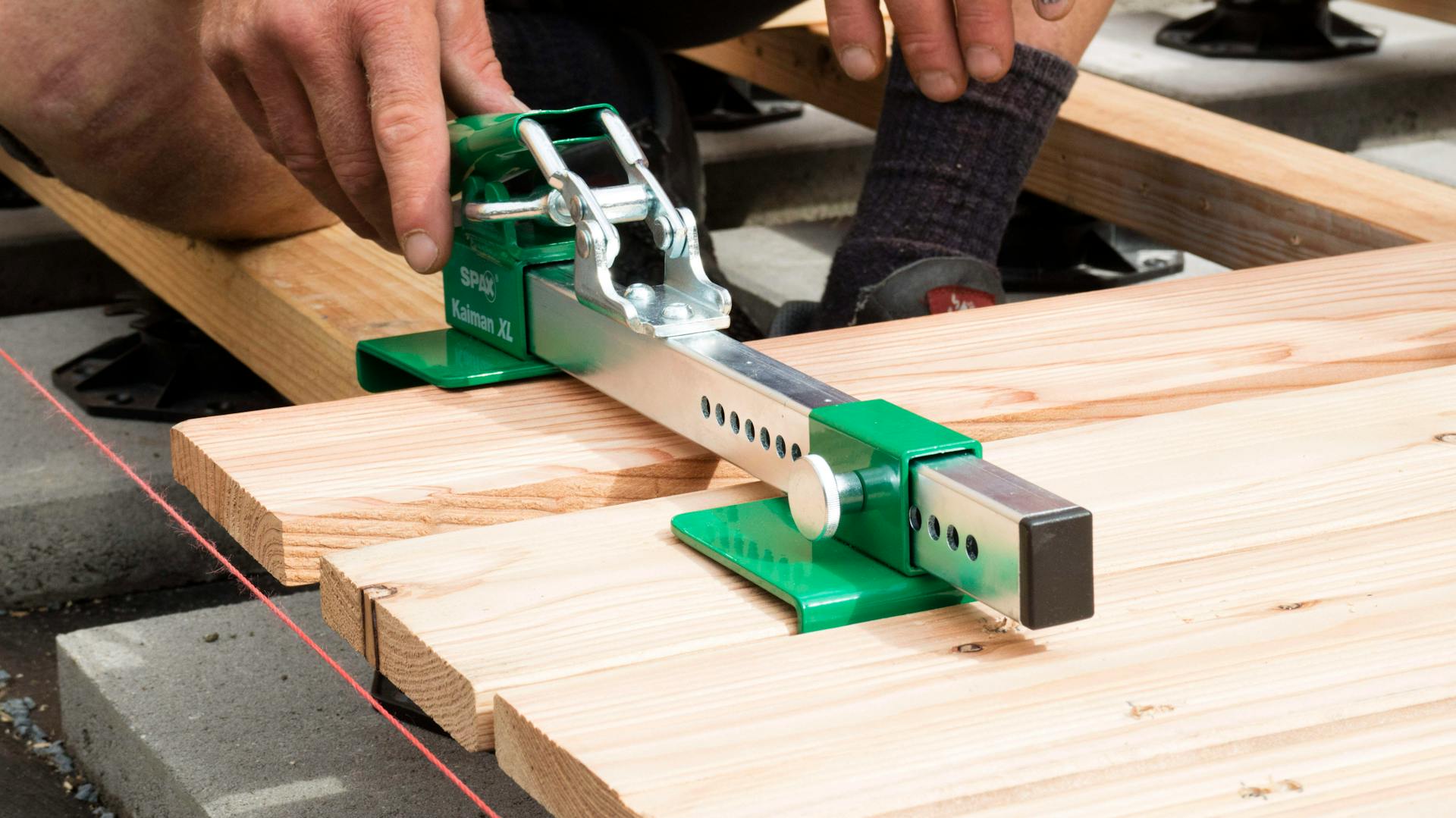 Ein Dielenspanner wird verwendet, um Terrassendielen im richtigen Abstand einzufügen.