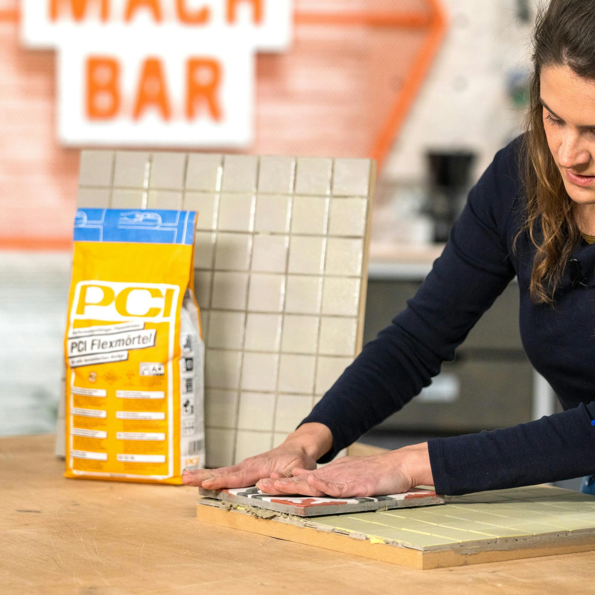 Handwerker verklebt die neuen Fliesen auf die alten Fliesen.