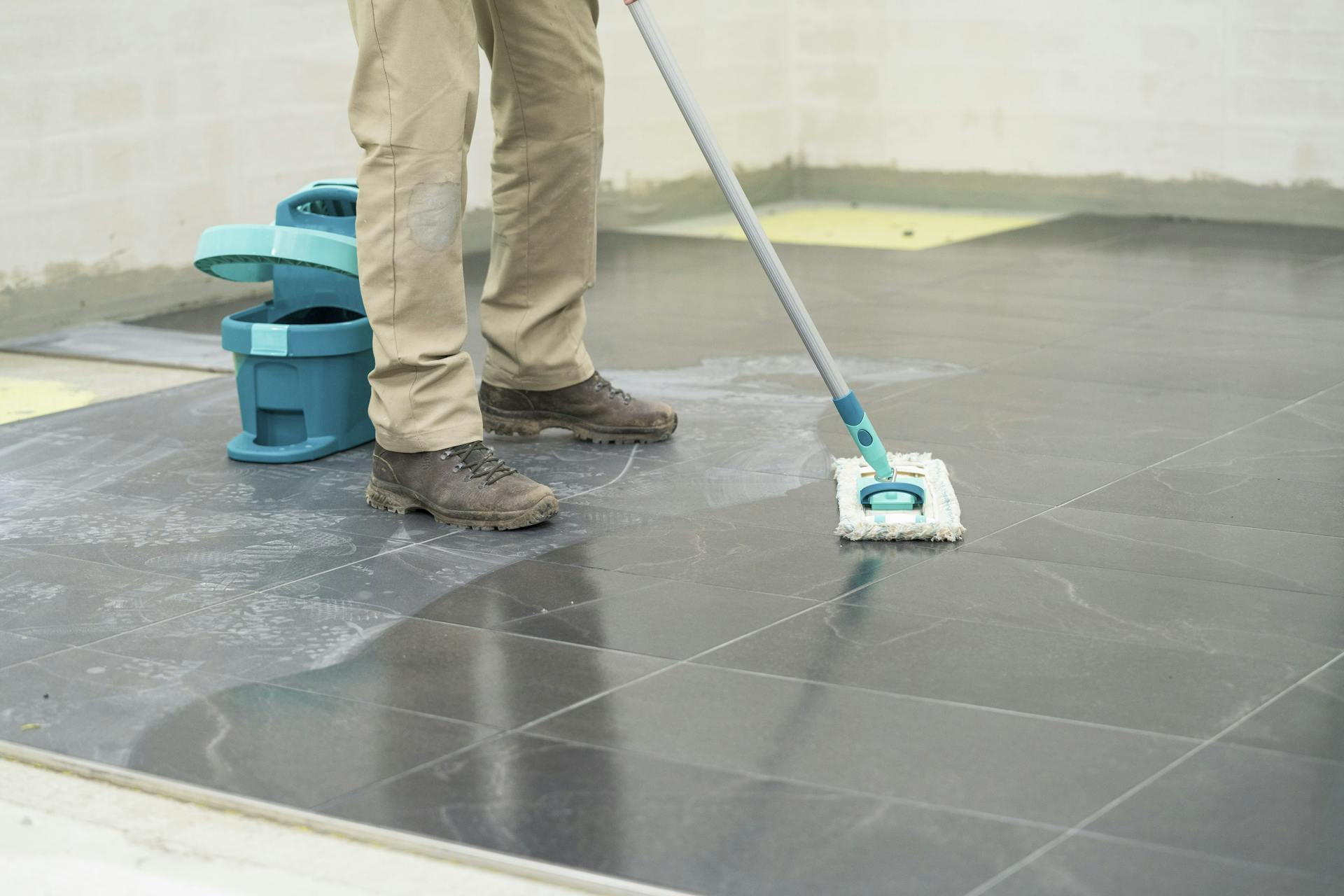 L’appassionato del fai-da-te rimuove il velo di cemento dalle piastrelle.