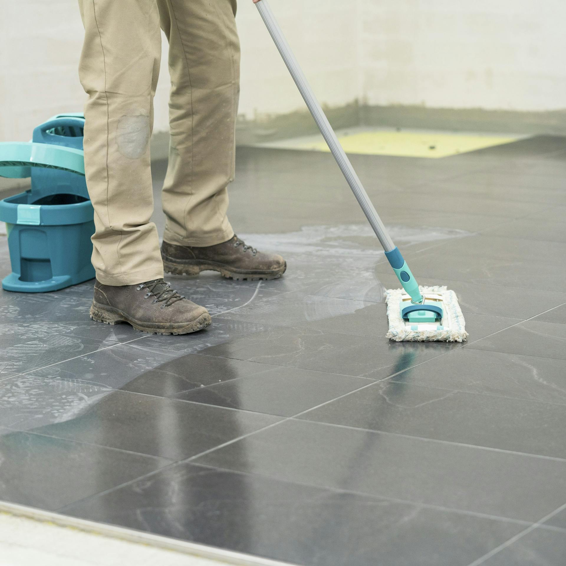 Heimwerker entfernt den Betonschleier von den Fliesen.