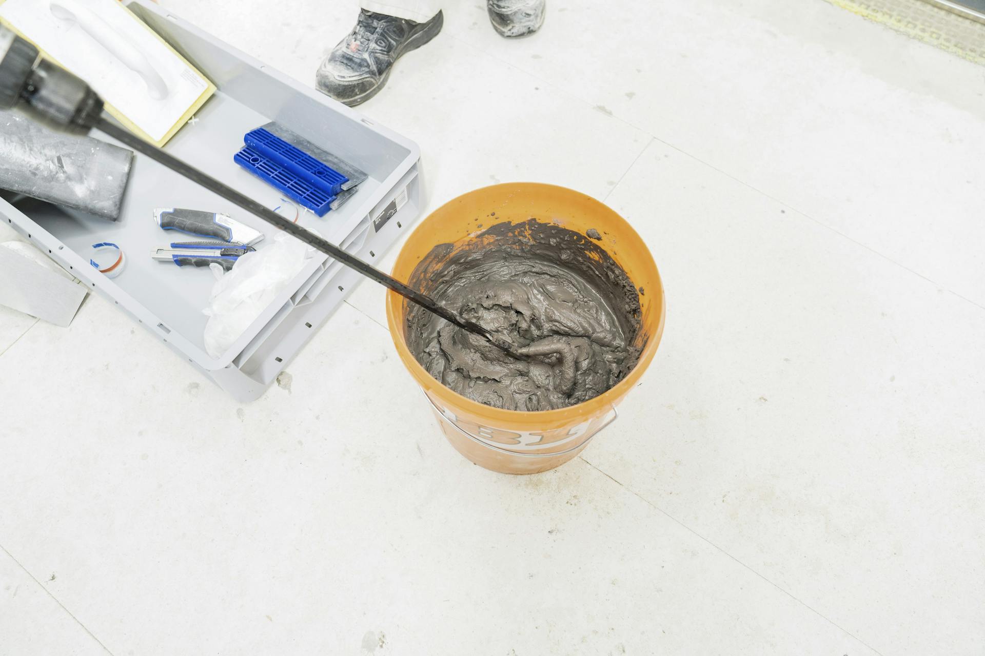 La malta per fughe è stata mescolata in un secchio grande.