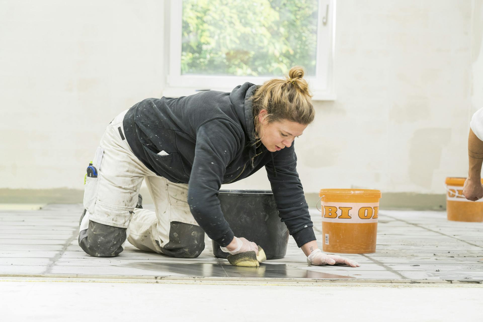 L’appassionata del fai-da-te rimuove la malta in eccesso con una spugna.