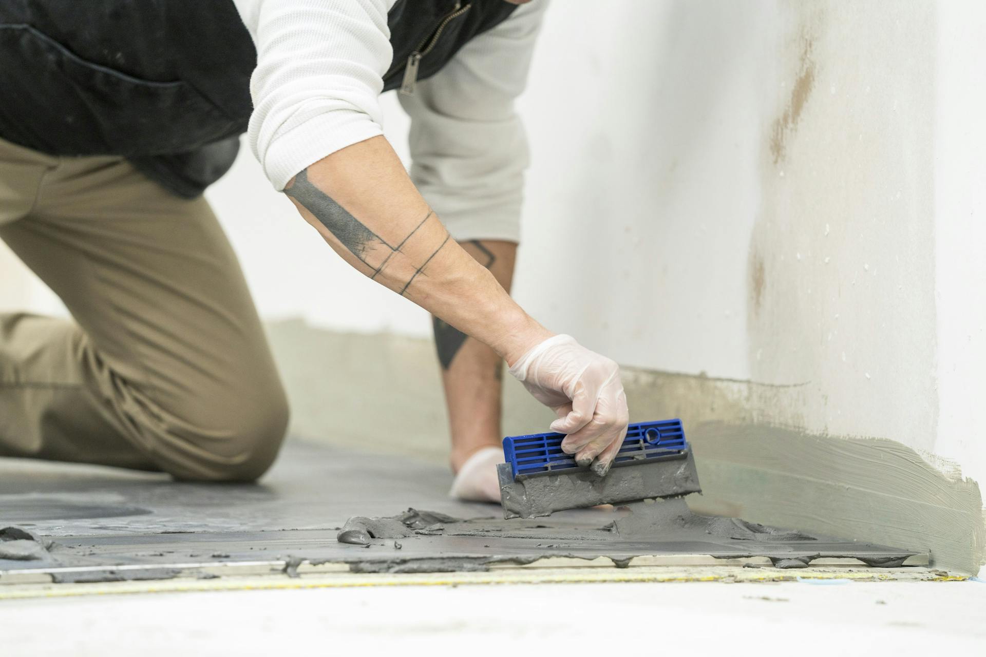 L’appassionato del fai-da-te applica la malta sulle piastrelle.