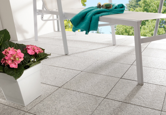 Eine Terrasse wurde mit Natursteinfliesen gefliest.