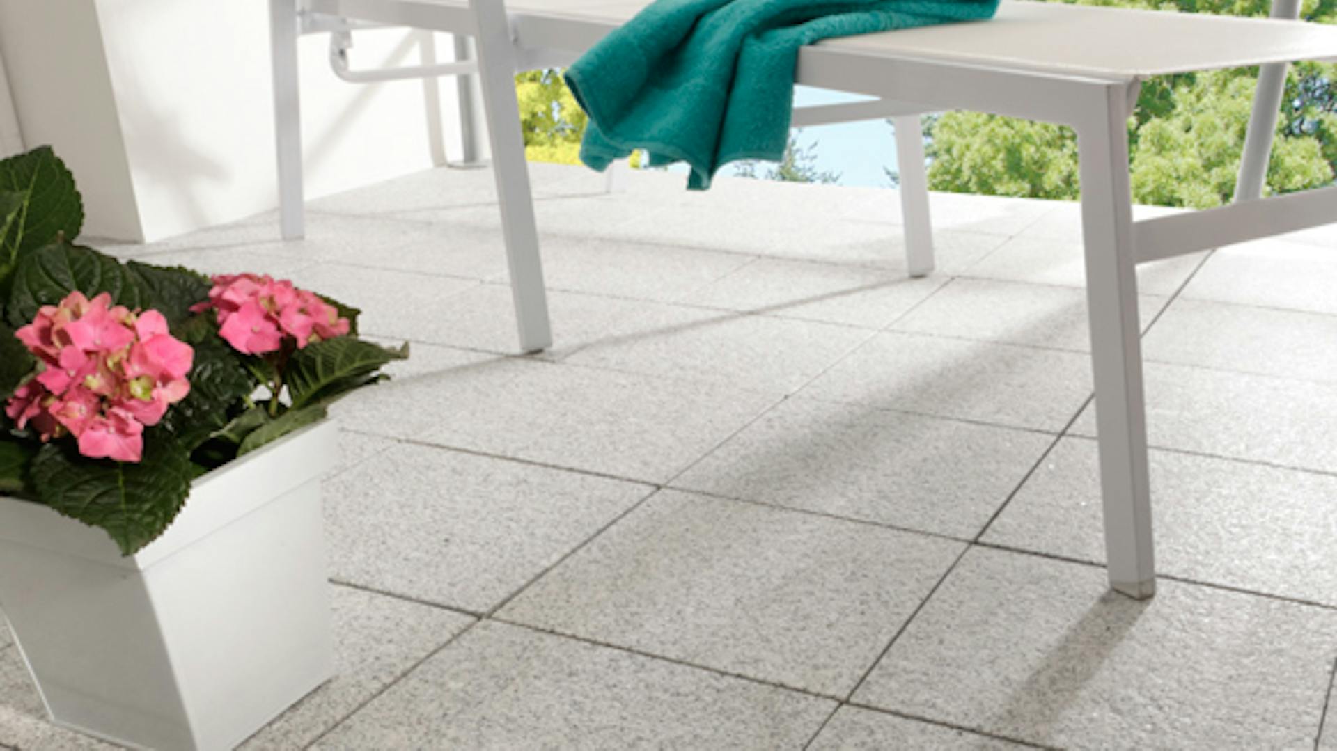 Eine Terrasse wurde mit Natursteinfliesen gefliest.