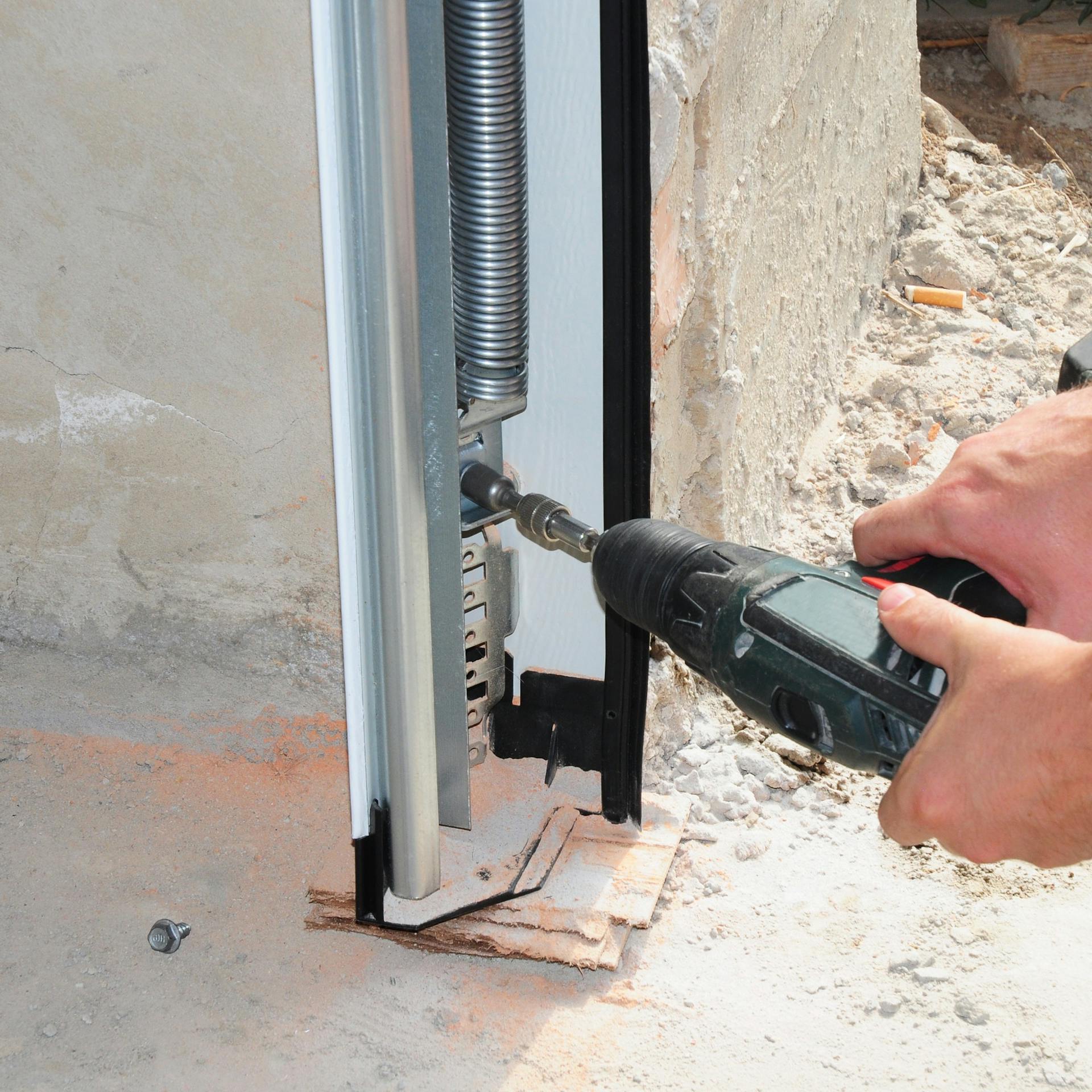 Seitliche Zugfeder eines Sektionaltores wird montiert