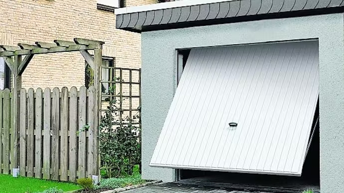 Garage mit halb geöffnetem weißem Schwingtor
