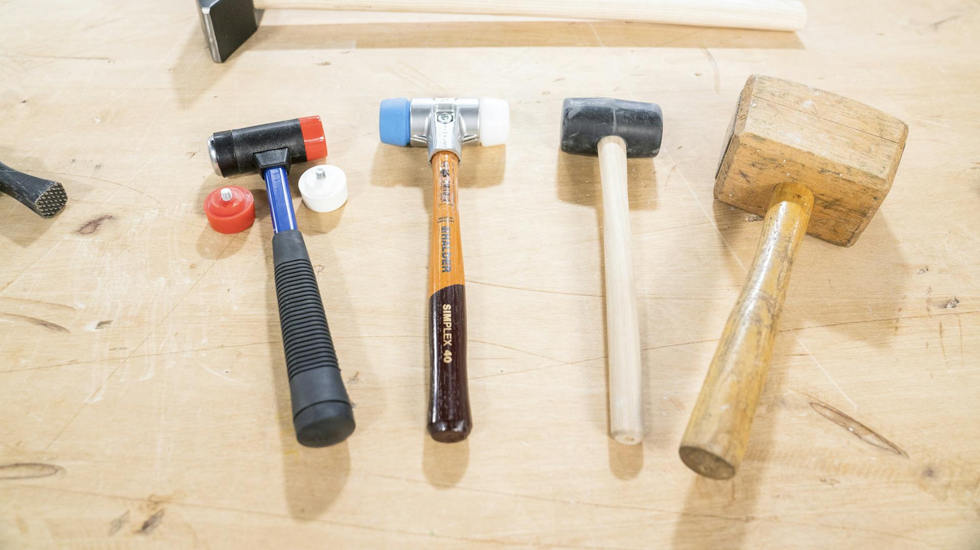 Verschiedene Hammer liegen auf einem Tisch.