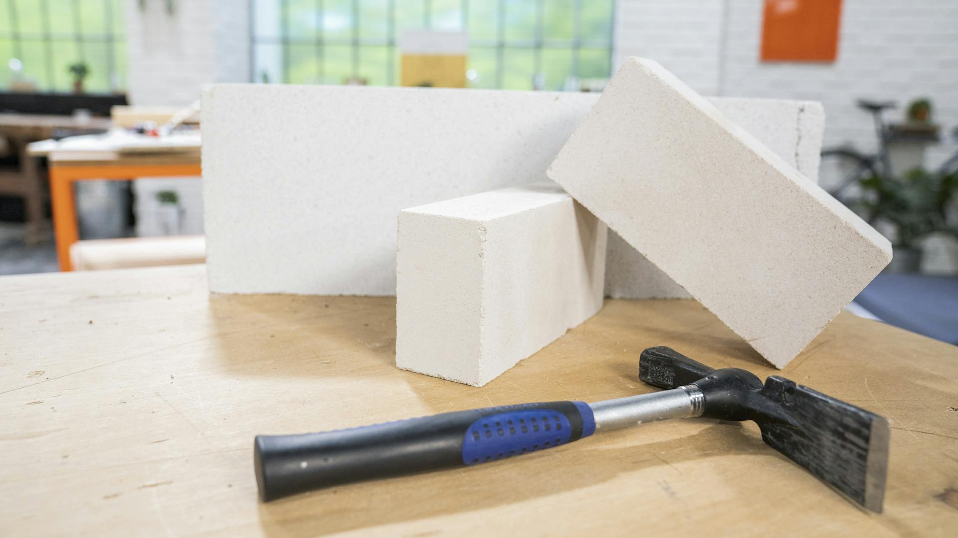 Maurerhammer liegt mit Wandsteinen auf dem Tisch.