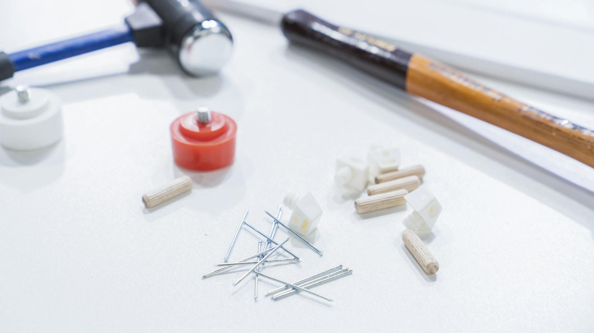 Schonhammer liegt auf dem Tisch mit Nägeln und Dübeln.