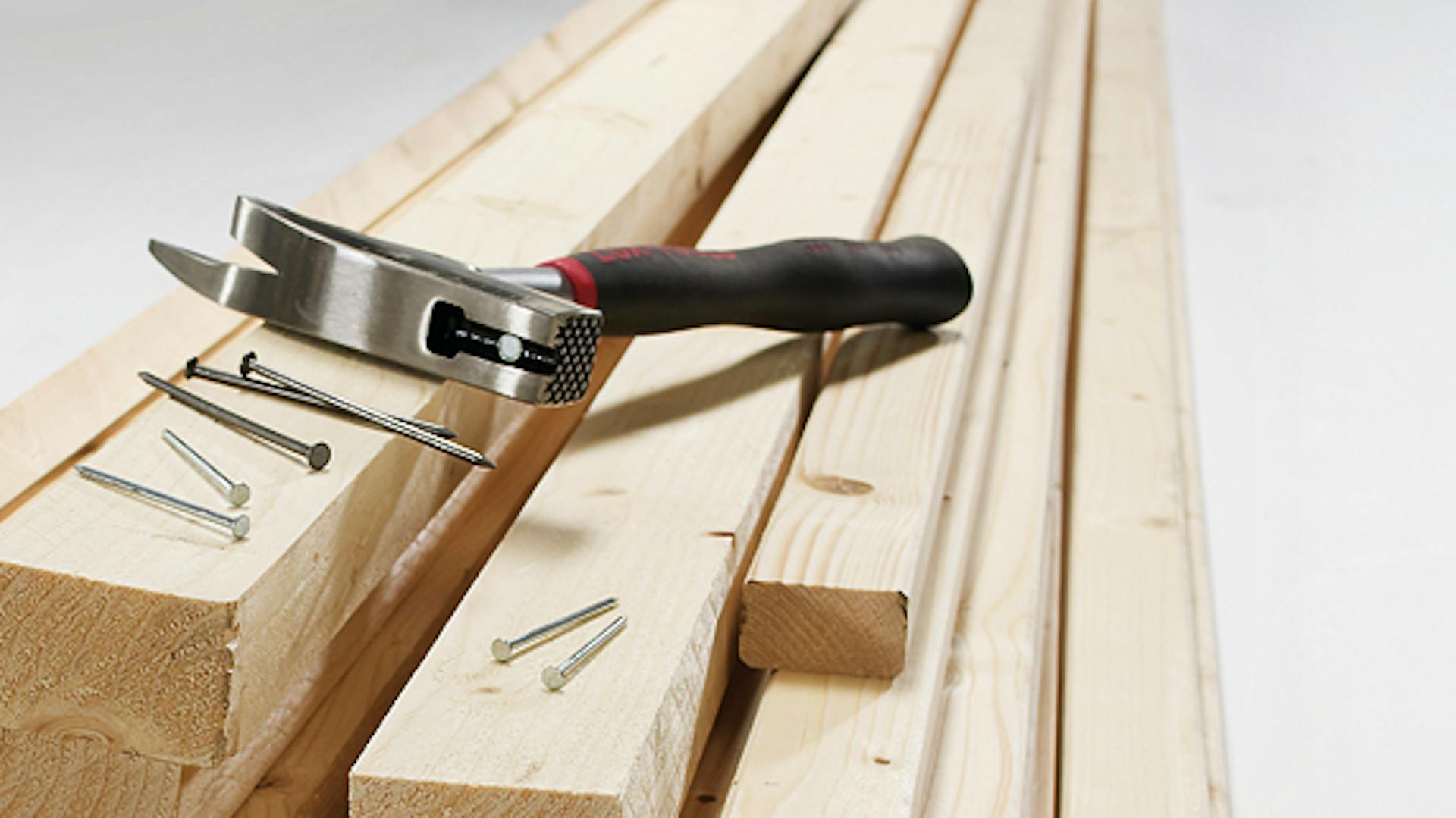 Hammer mit Nägeln auf Holzlatten