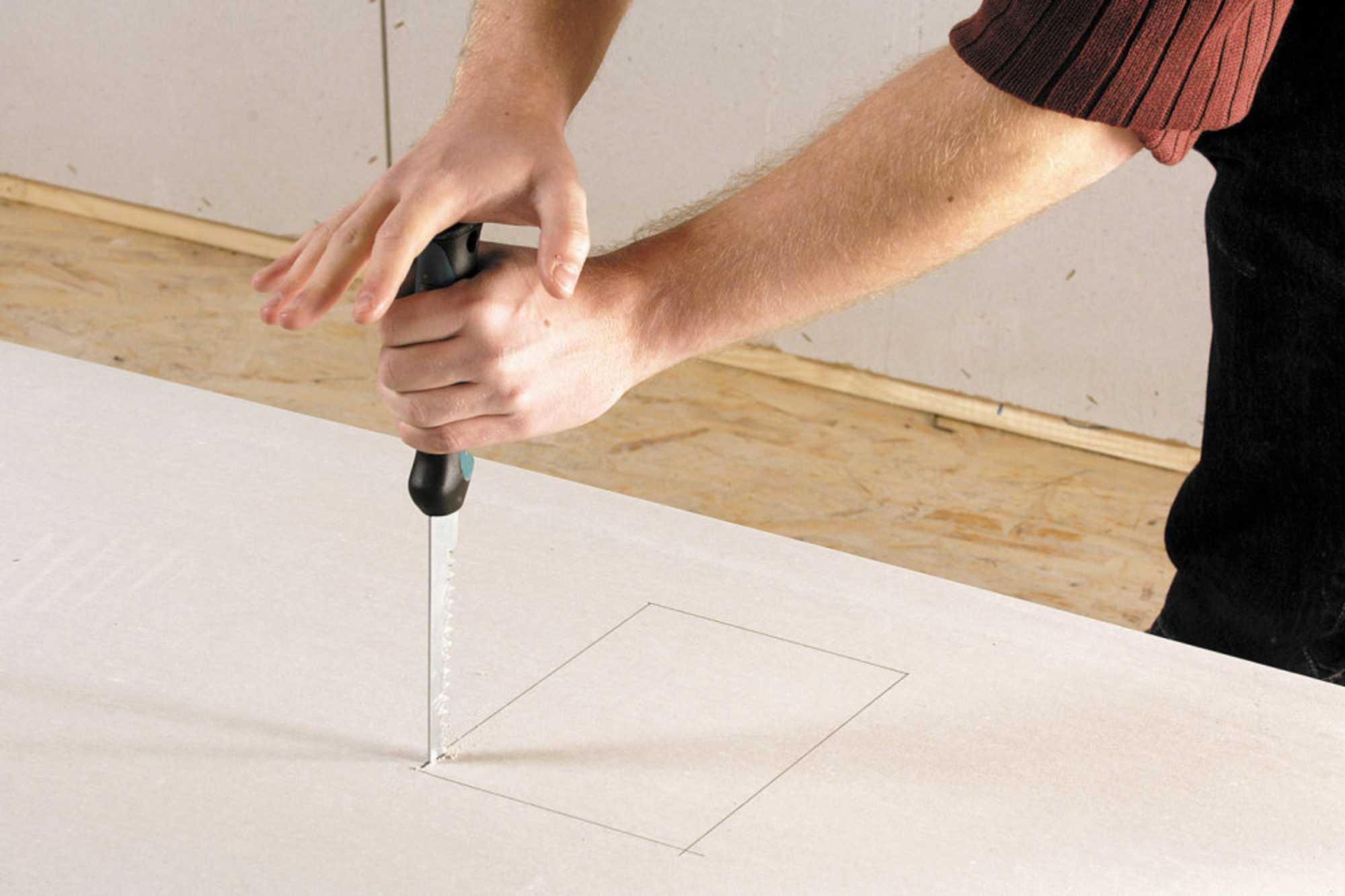 Hände sägen Holz mit Stichsäge