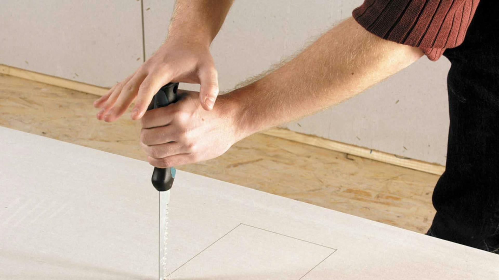 Hände sägen Holz mit Stichsäge