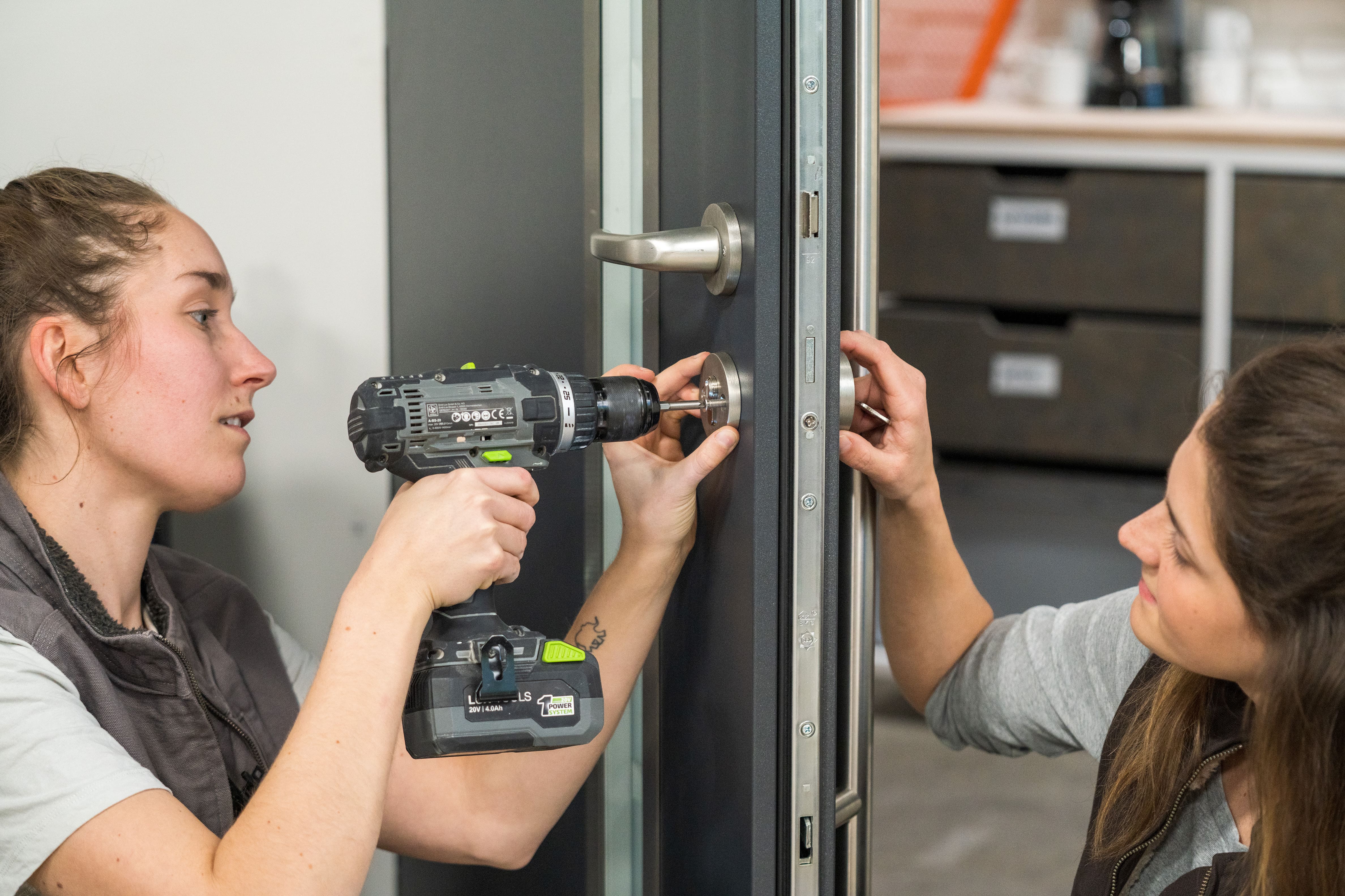 Heimwerkerinnen fixieren den Zylinder in der Türfalz.
