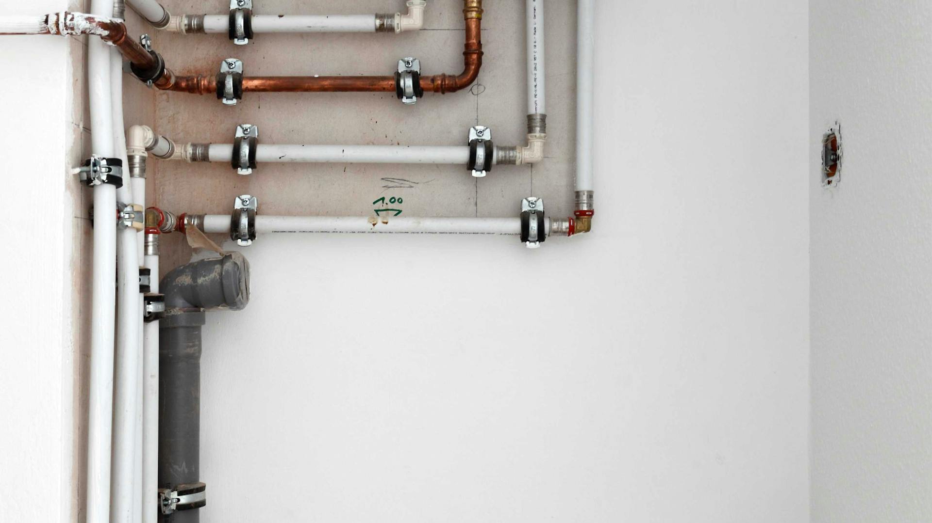 Heizungsrohre ohne Isolierung an der Wand installiert.