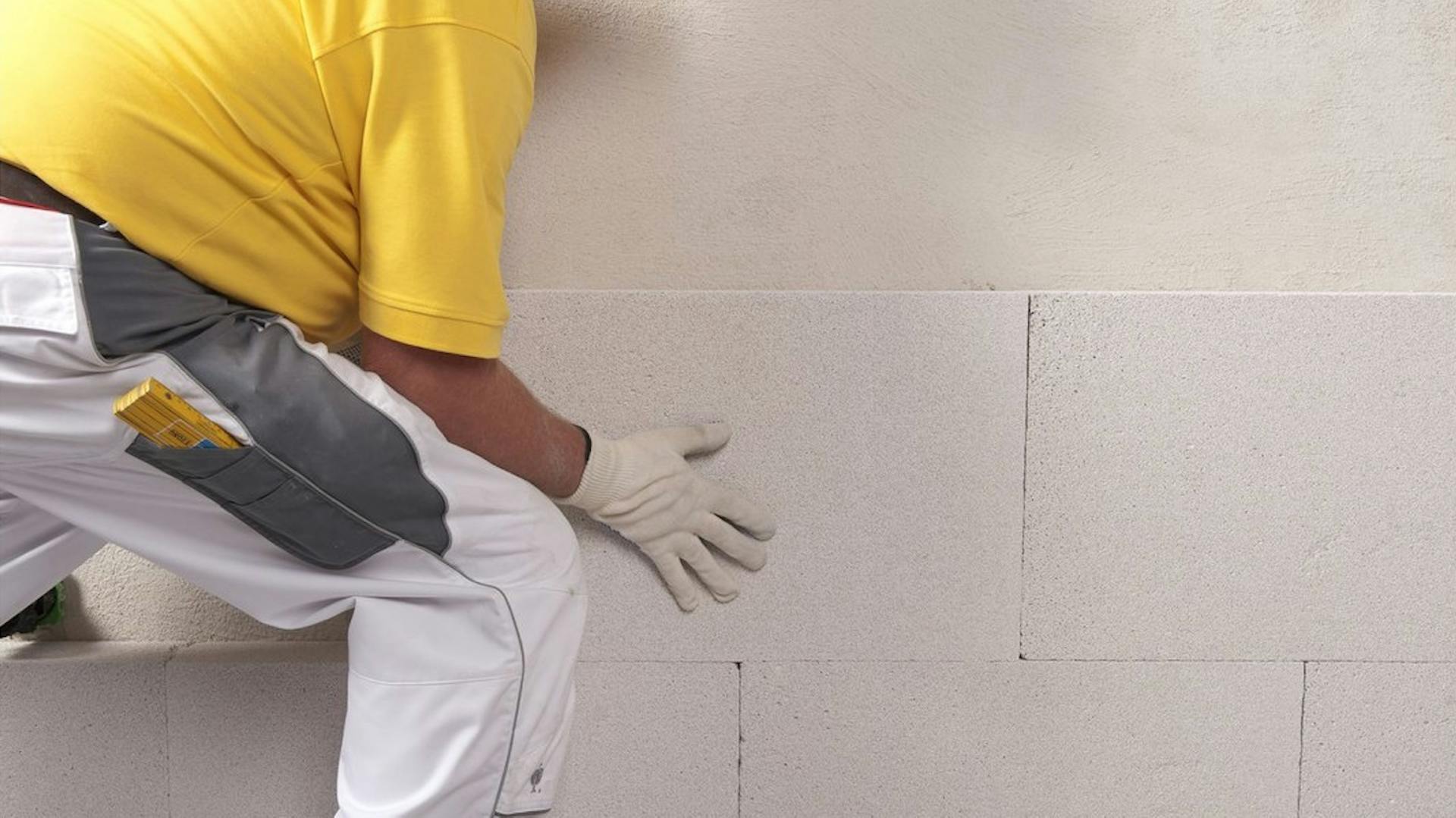 Heimwerker dämmt Innenwand mit Dämmplatten.