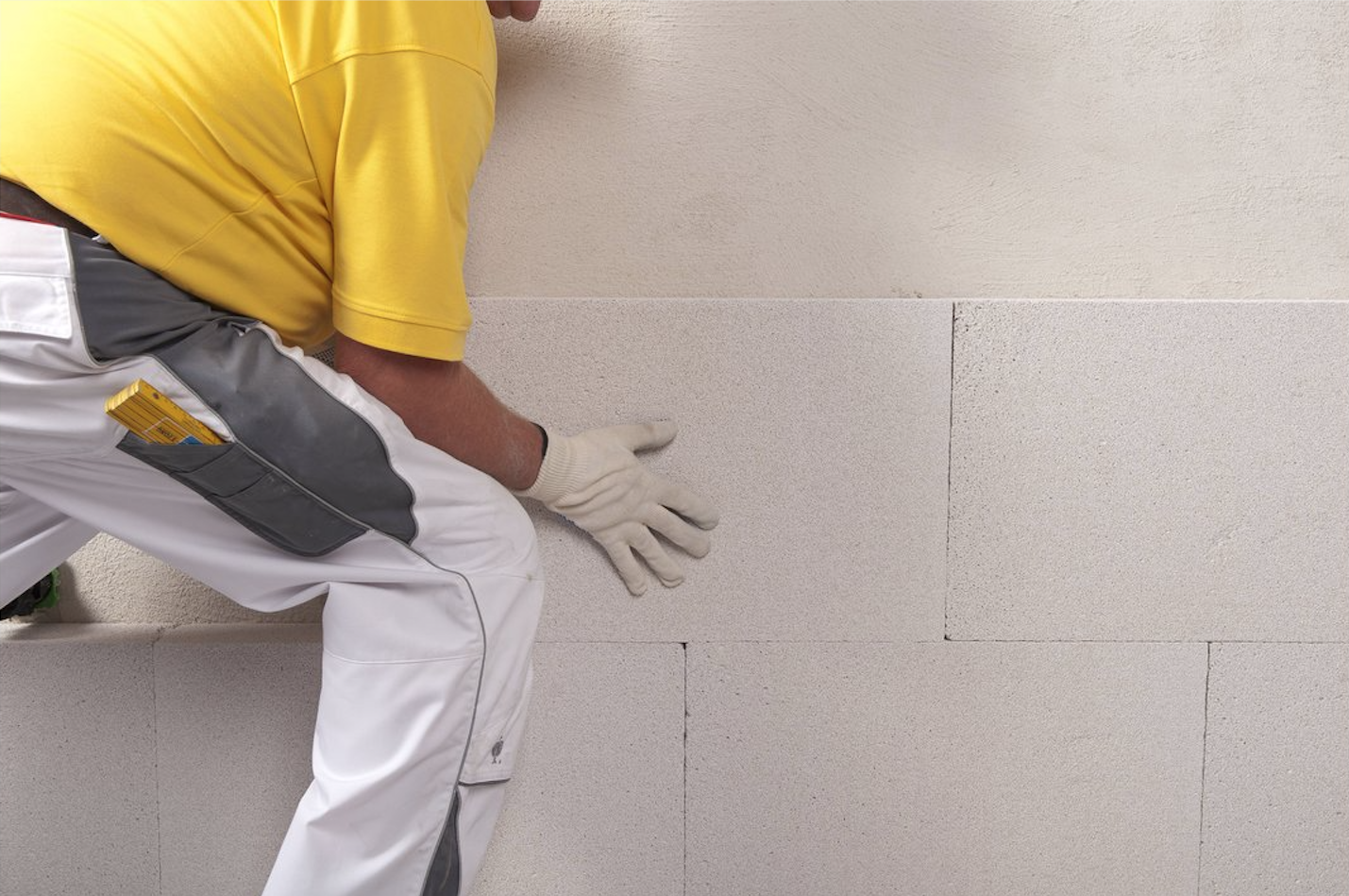 Heimwerker montiert Kalziumsilikat-Platte an der Wand.