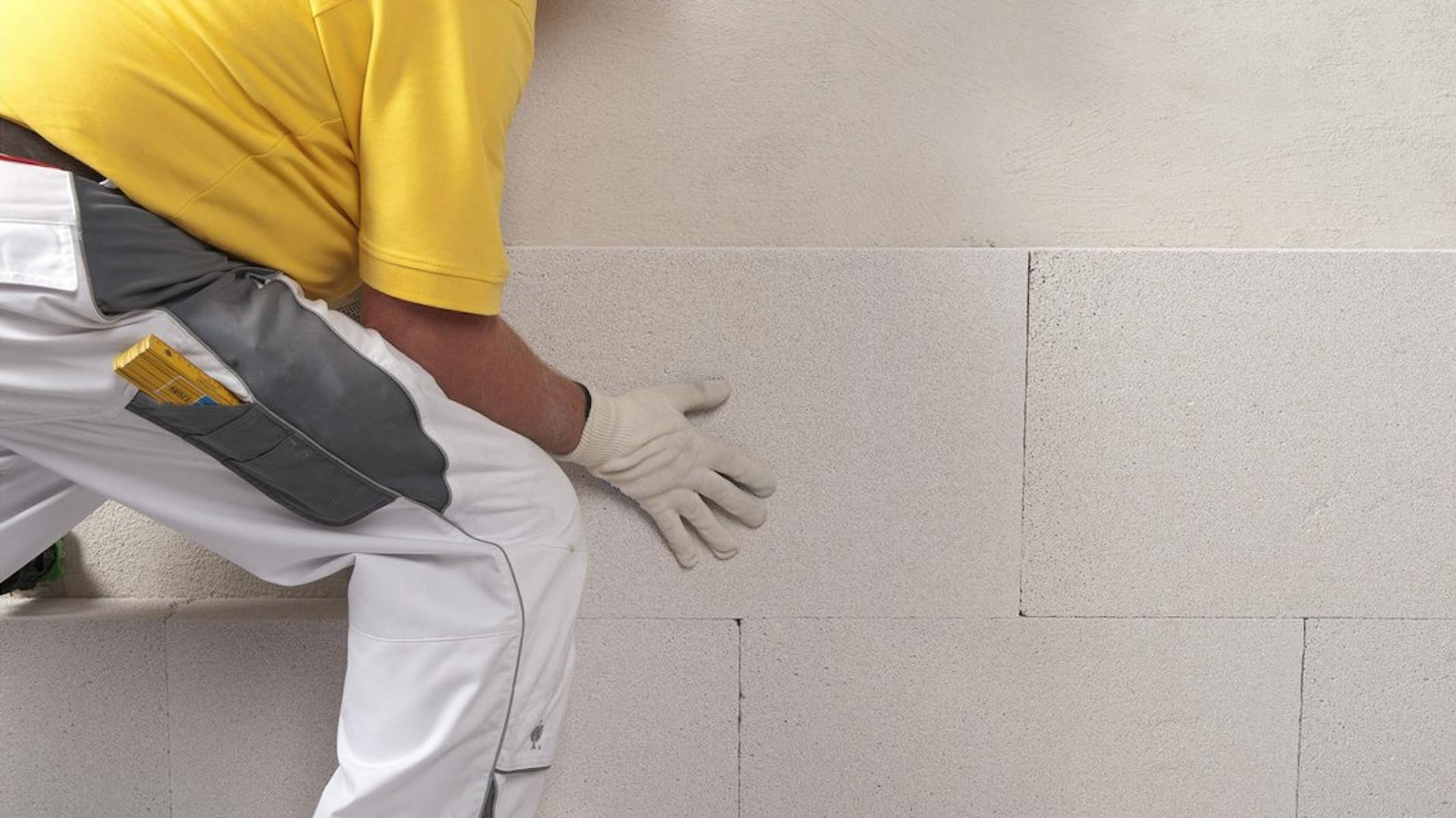 Heimwerker montiert Kalziumsilikat-Platte an der Wand.