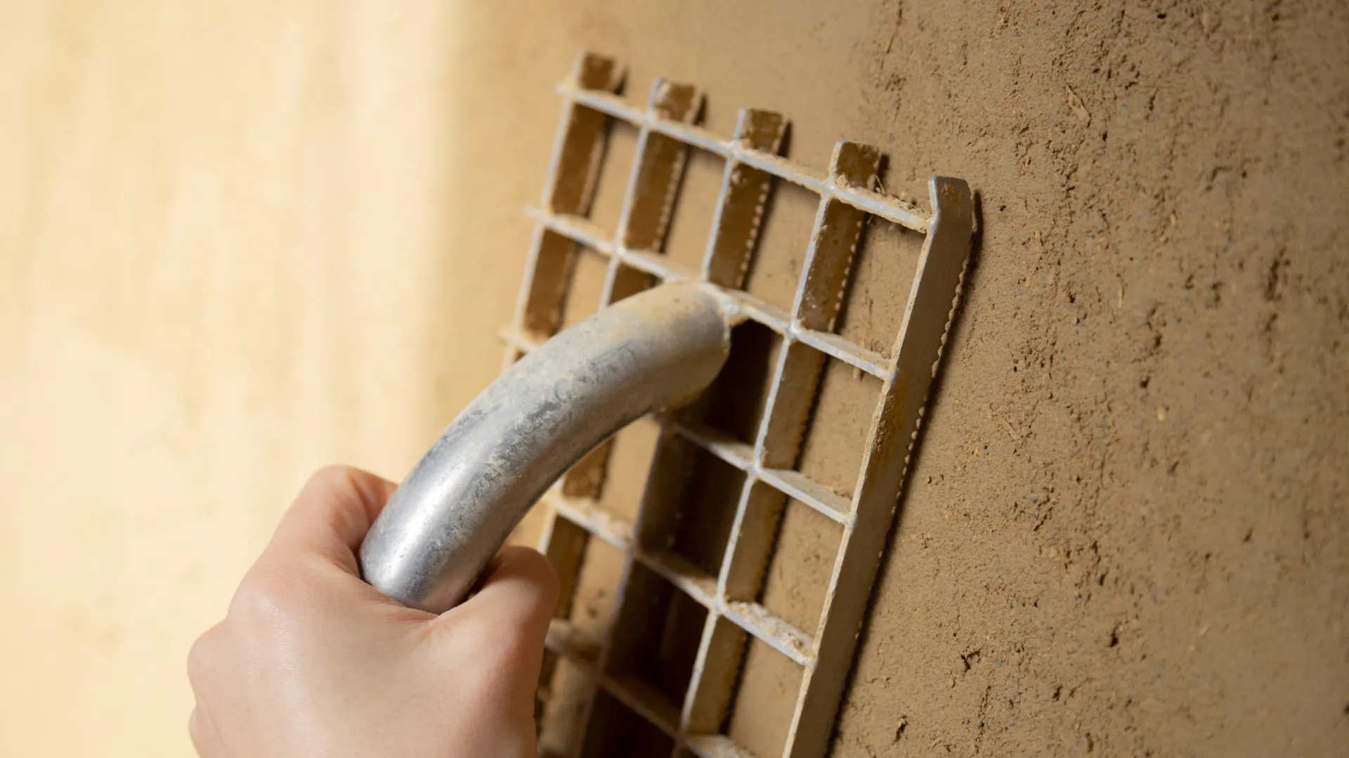 Kellerwand wird mit einem Gitter-Rabot verputzt.