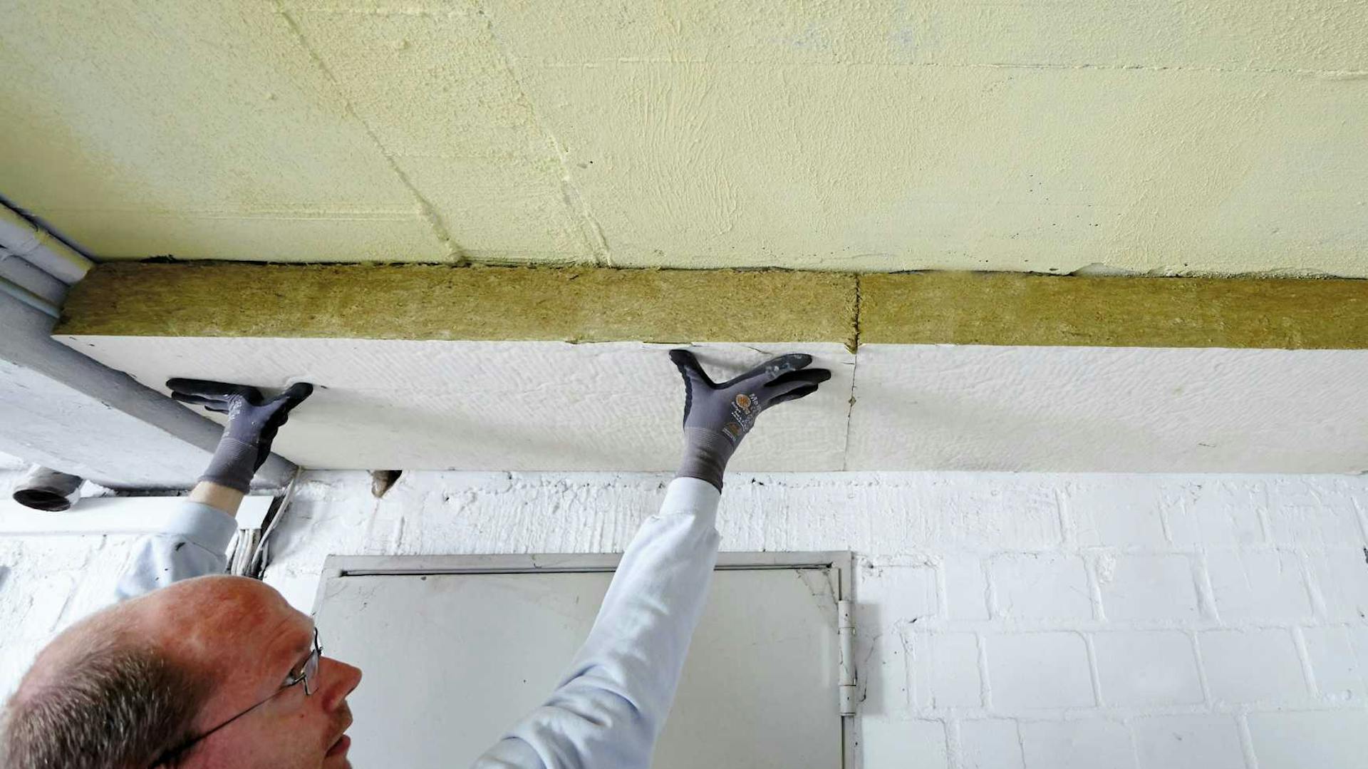 Kezek egy szigetelőlapon a pincefödémen