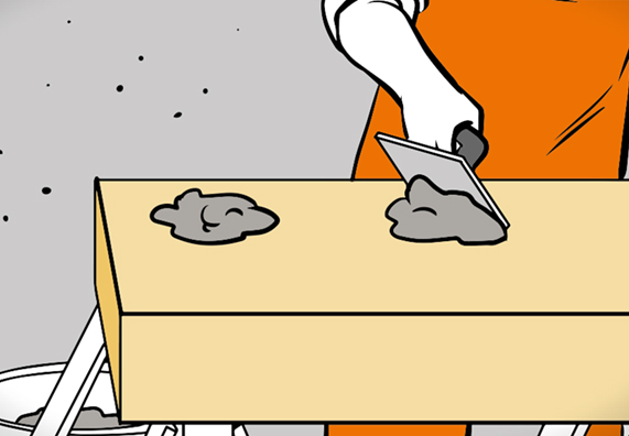 Hand mit Spachtel und Mörtel auf Dämmplatte.