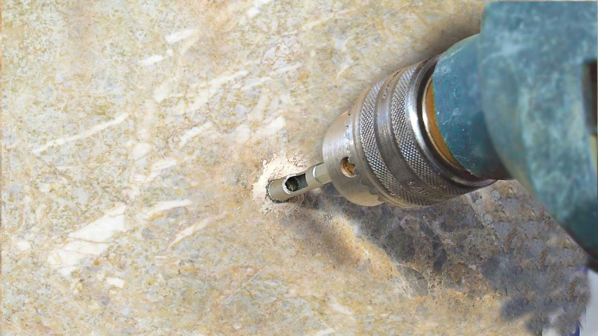 Bohrer bohrt Loch in Fliese