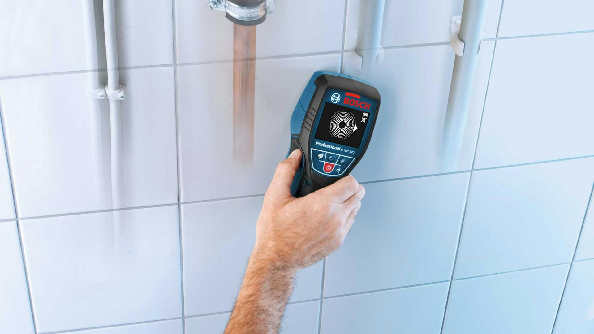 Hand hält Messgerät an Fliesen