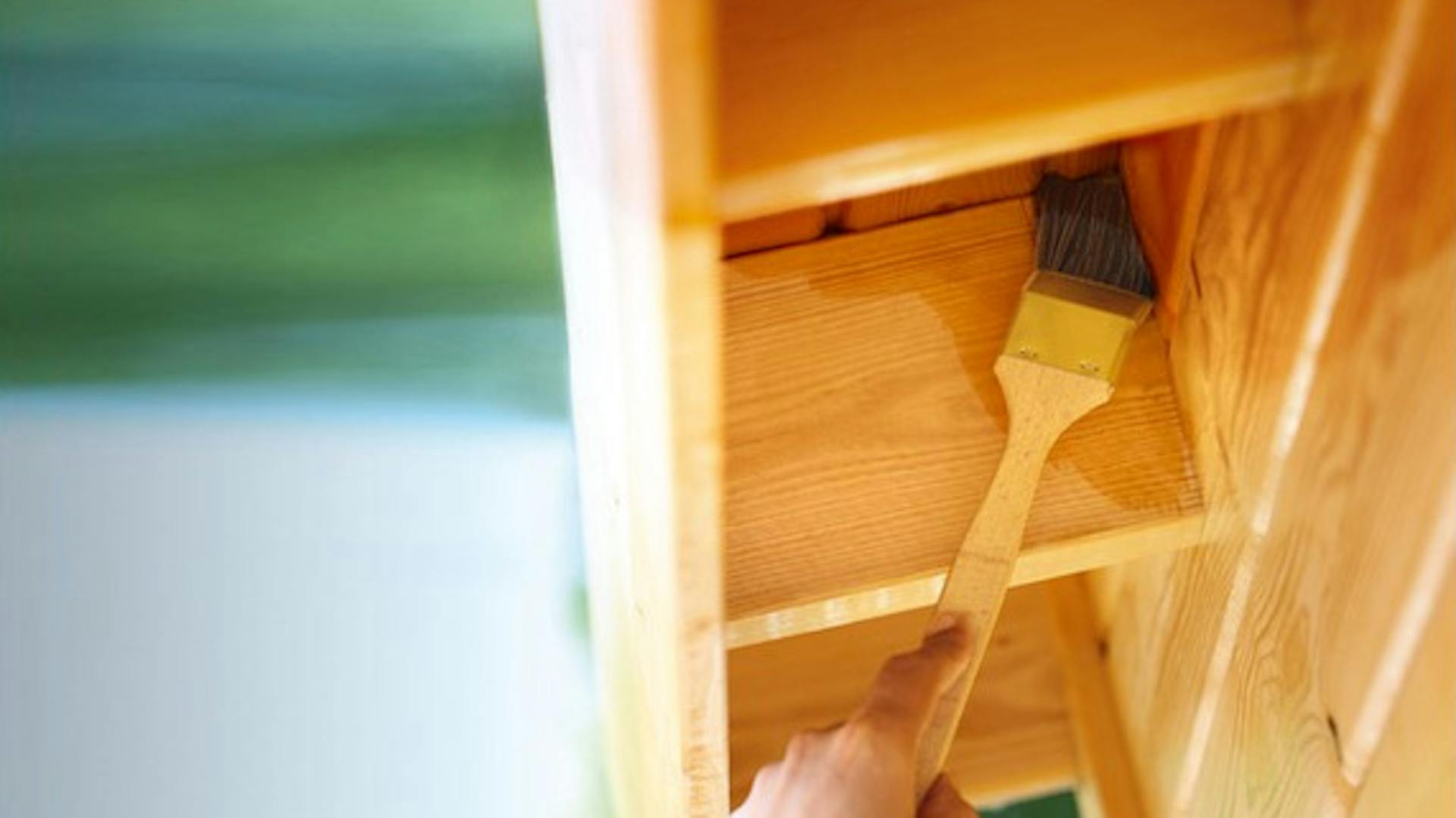 Lo scaffale in legno viene verniciato con un pennello per radiatori.