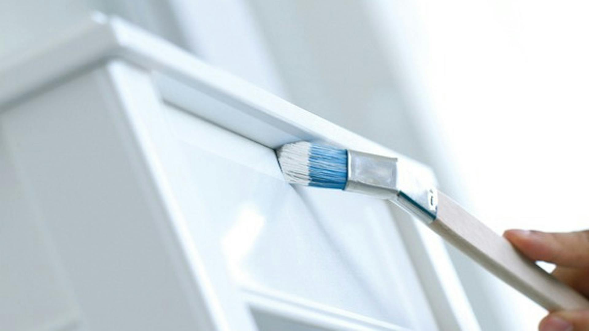 La cassettiera bianca è verniciata con un pennello piatto.